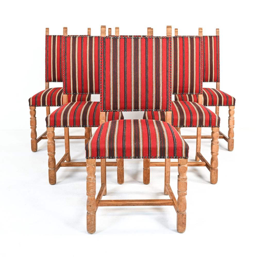 A set of six Danish mid-century dining side chairs attributed to designer Henning Kjaernulf, well-renowned for his iconic farmhouse-inspired carved oak furniture designs, c. 1960's. These charming provincial chairs feature high backs, reminiscent of