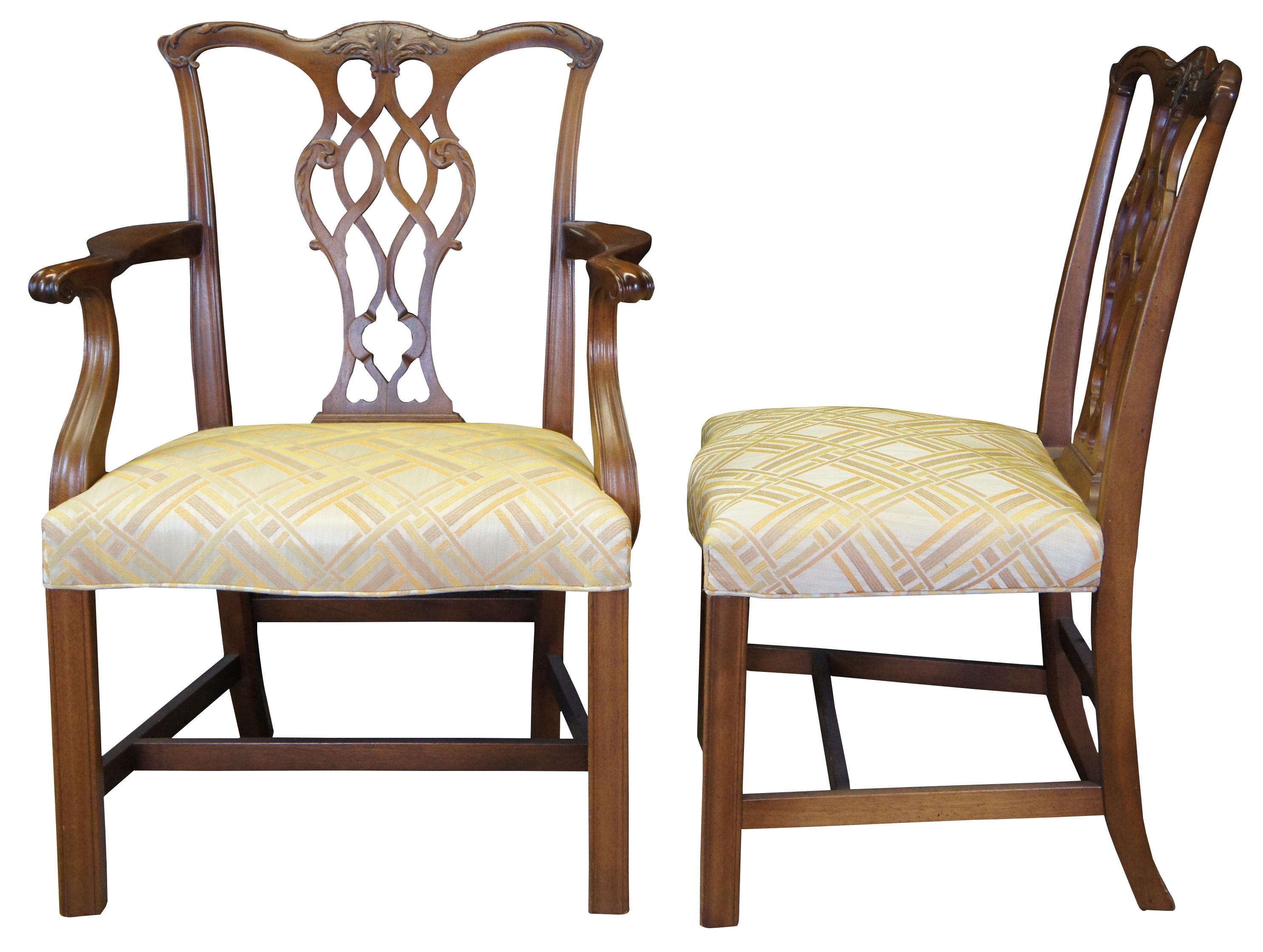 Six English Georgian or Chippendale style mahogany dining chairs by Baker Furniture. Features a medium brown finish, serpentine carved crest rail over pierced pretzel back and straight legs connected by an H stretcher. Upholstered in a yellow, brown