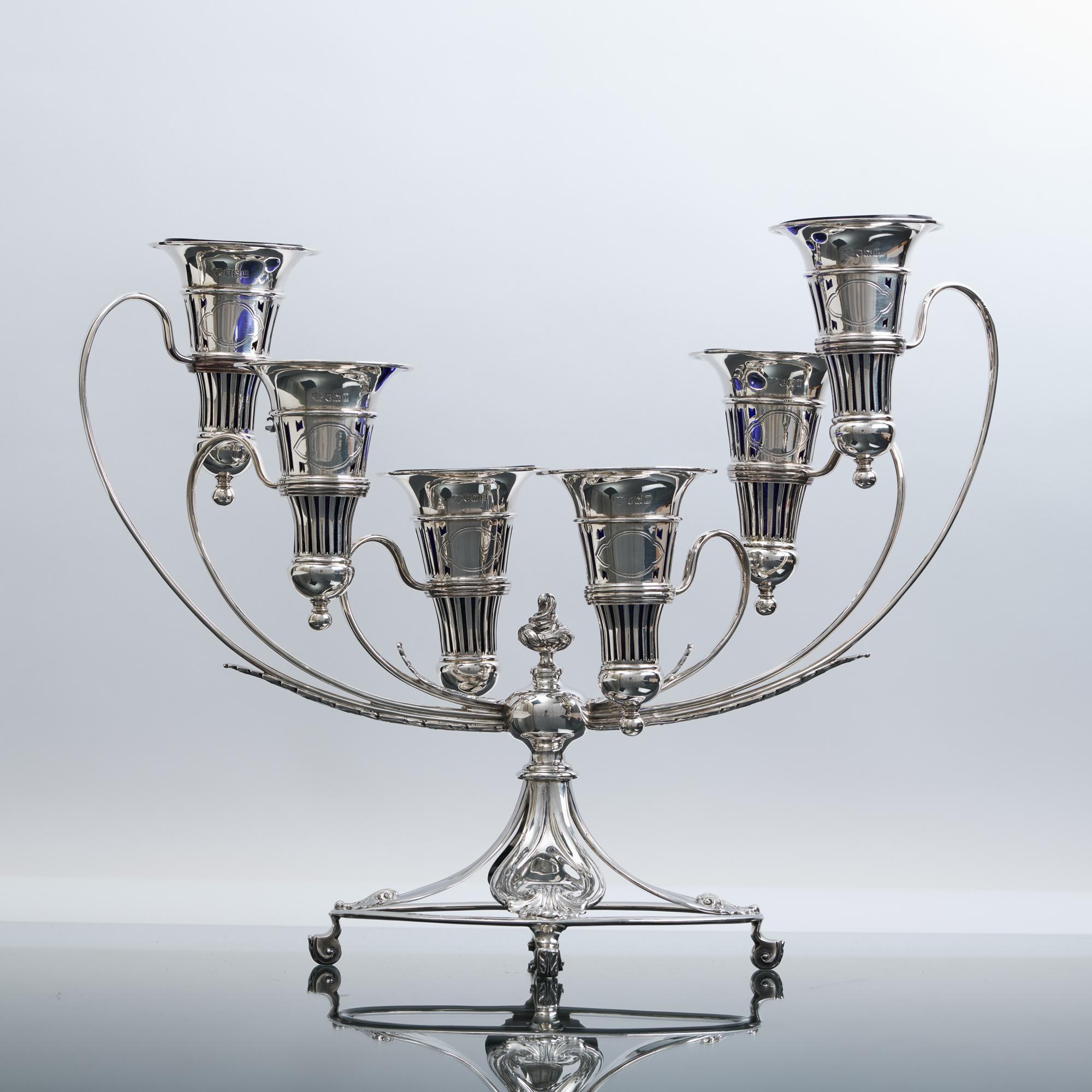 Ce magnifique et inhabituel centre de table en argent ancien percé est composé de six vases à fleurs amovibles placés dans un cadre incurvé vers le haut. Les bras en fil de fer et feuilles d'acanthe s'élèvent d'une base ovale incorporant des