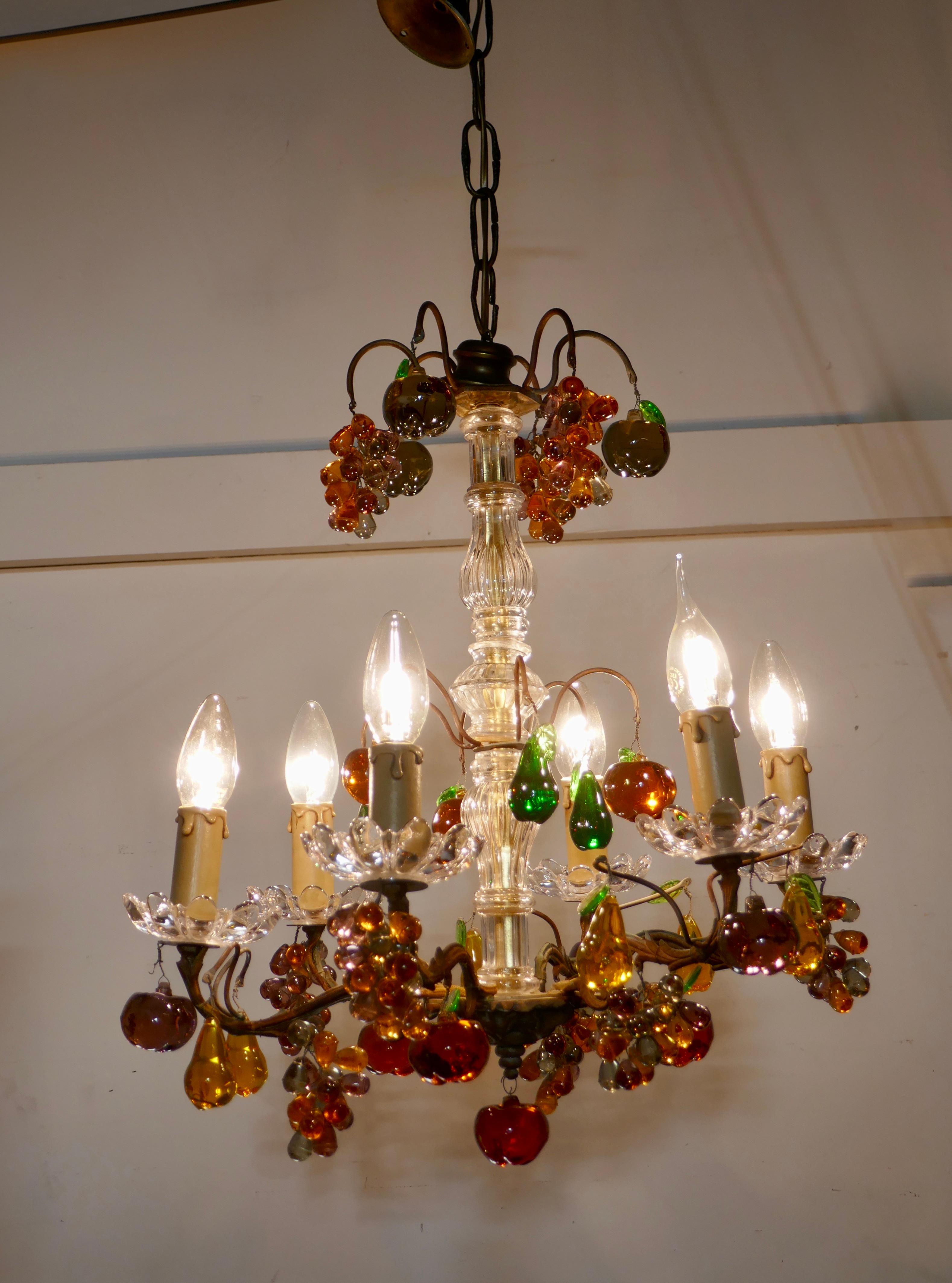 6 branch chandelier hung with colored crystal fruits, grapes, apples and pears

This is a stunning piece, the aged brass frame is hung with bunches of amber grapes, amethyst apples and pears in lemon and green with occasional green leaves
The