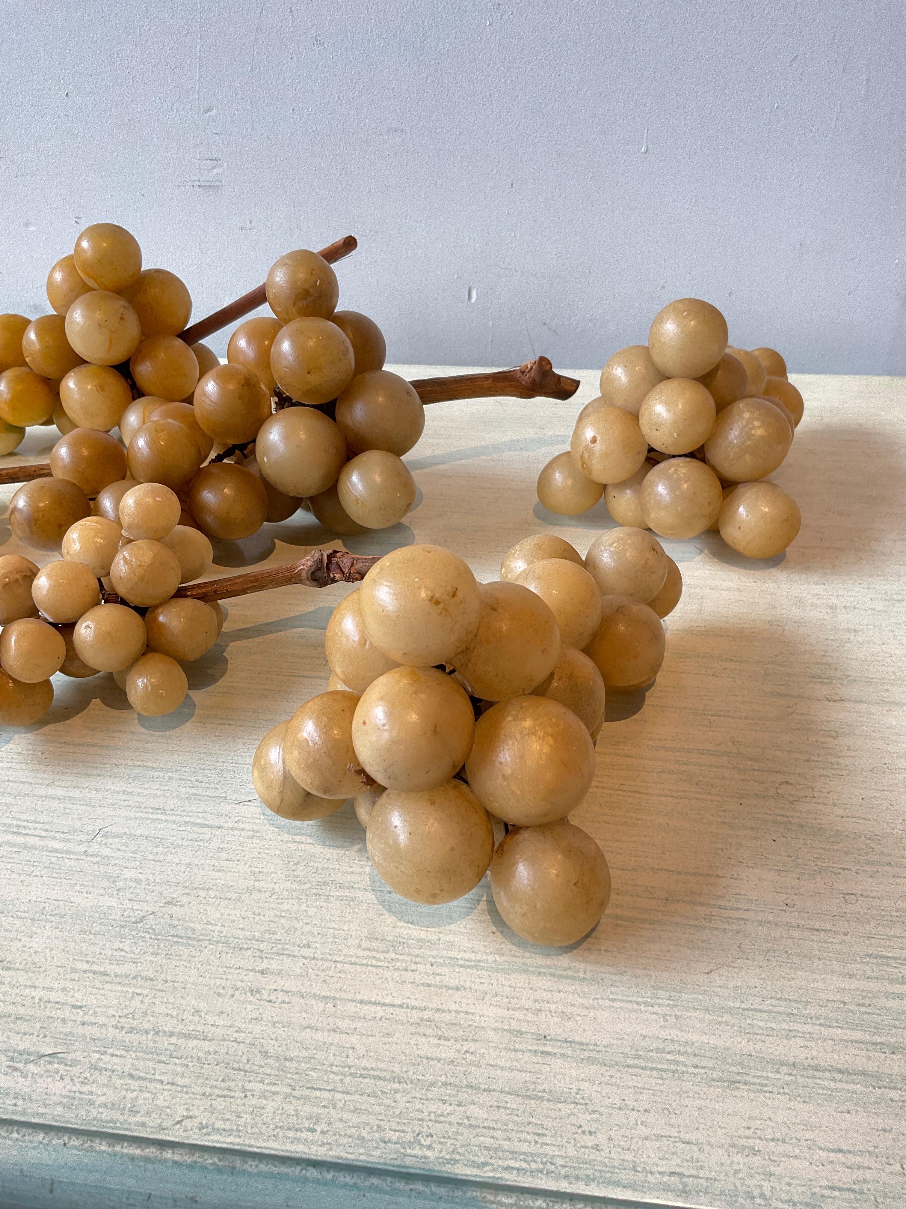 6 Clusters of marble grapes. One cluster has no stem, one cluster has the stem but it’s broken off.