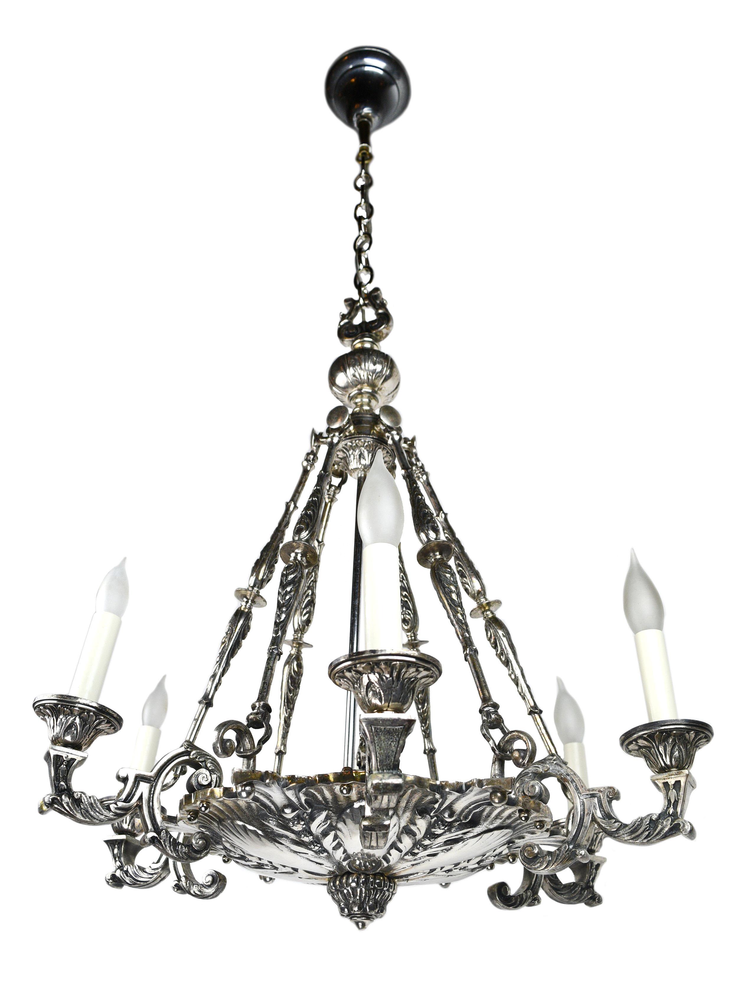 This stunning chandelier has lovely silver plating and features an intricately detailed floral pattern. The fine craftsmanship found through within the silver plating of this chandelier is truly eye-catching!