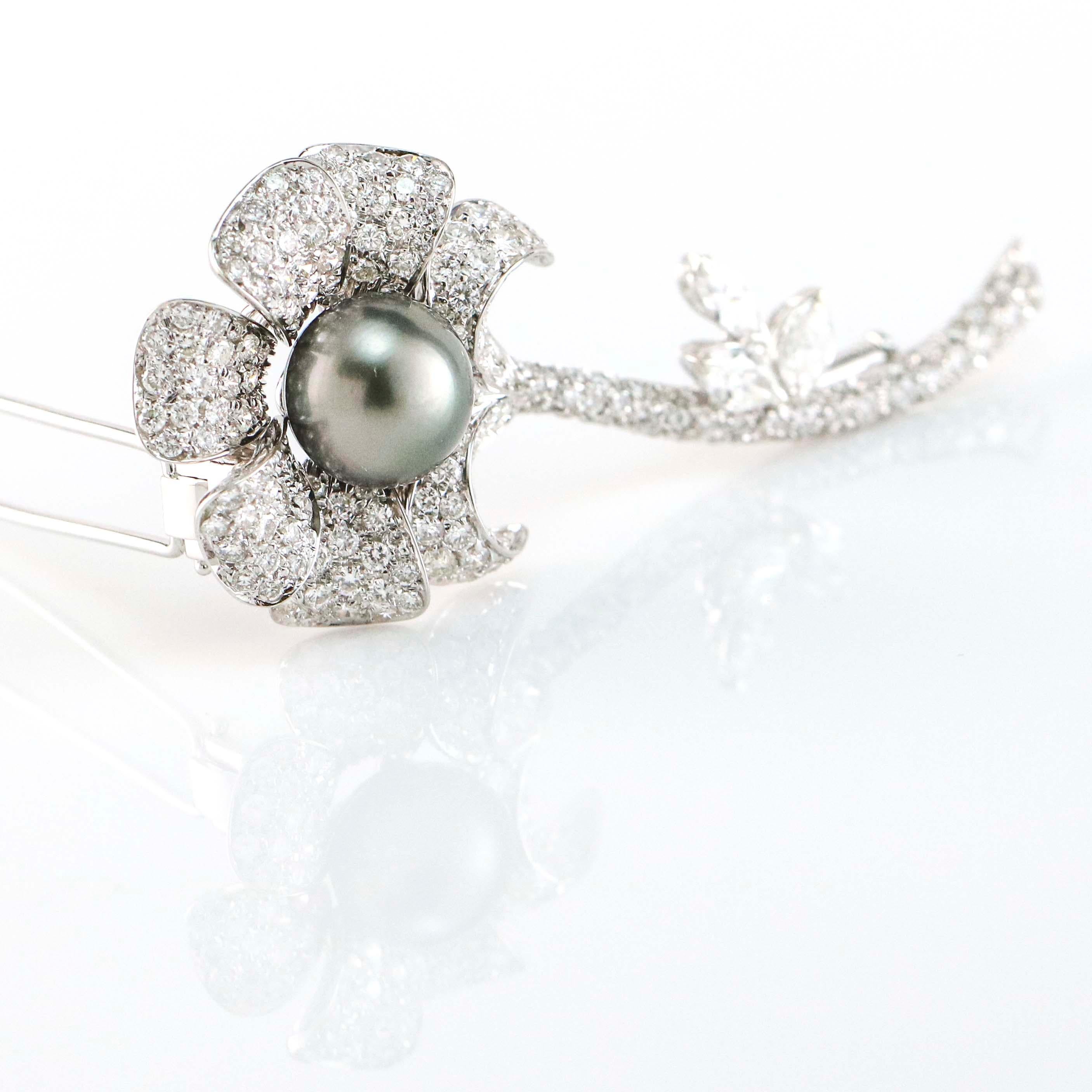 Flower brooch with double pinstem and trombone catch on the back. The long stem flower embellished with 220 round cut diamonds, at the center of the flower an 11mm Tahitian pearl. Signed 2243 AL. Diamonds,  H-I VS-SI.