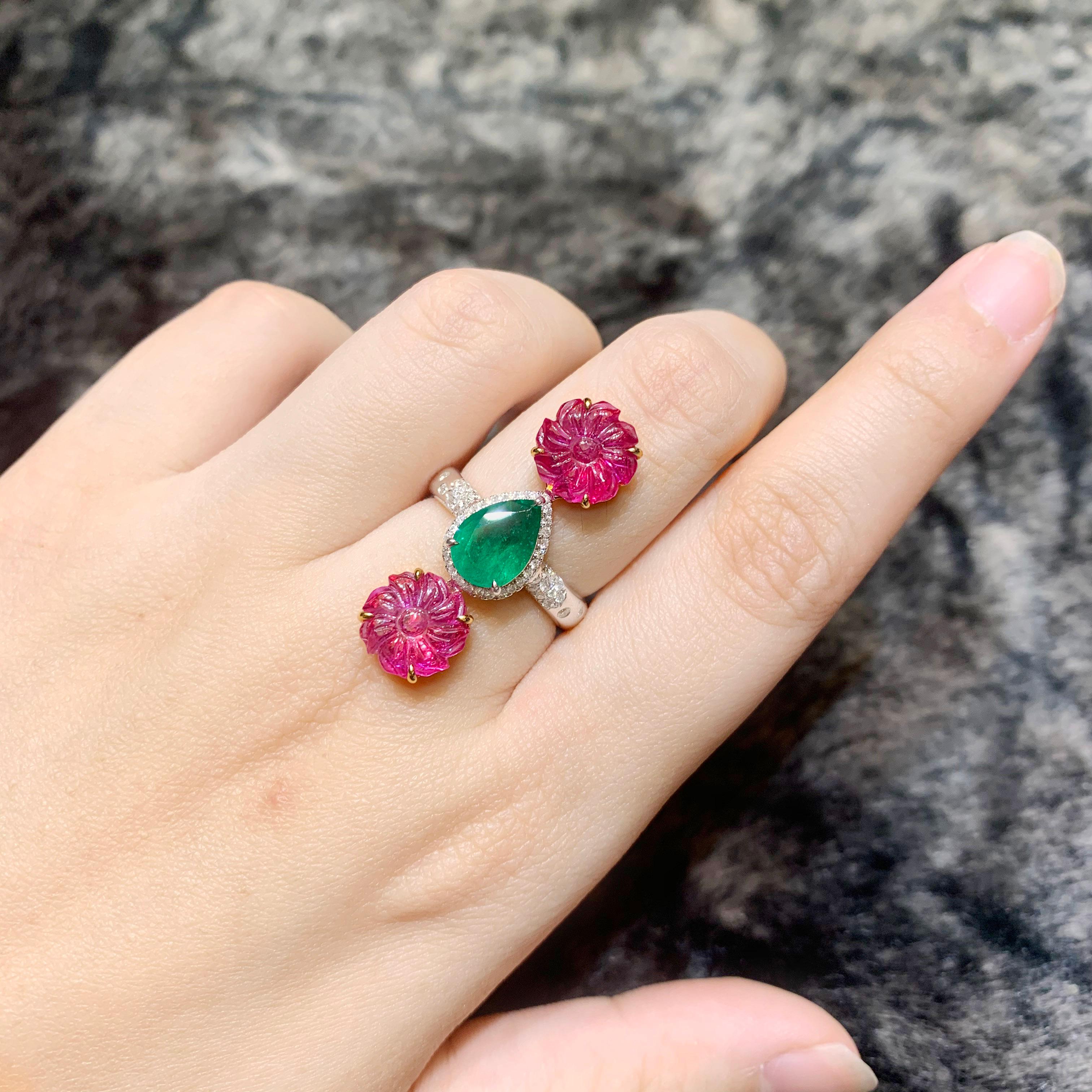 Intricately carved , two pieces of vivid red Mozambique ruby is set along 1.55 carat of Zambian vivid green emerald. The ring also has 0.25 carat of white round brilliant diamond.
