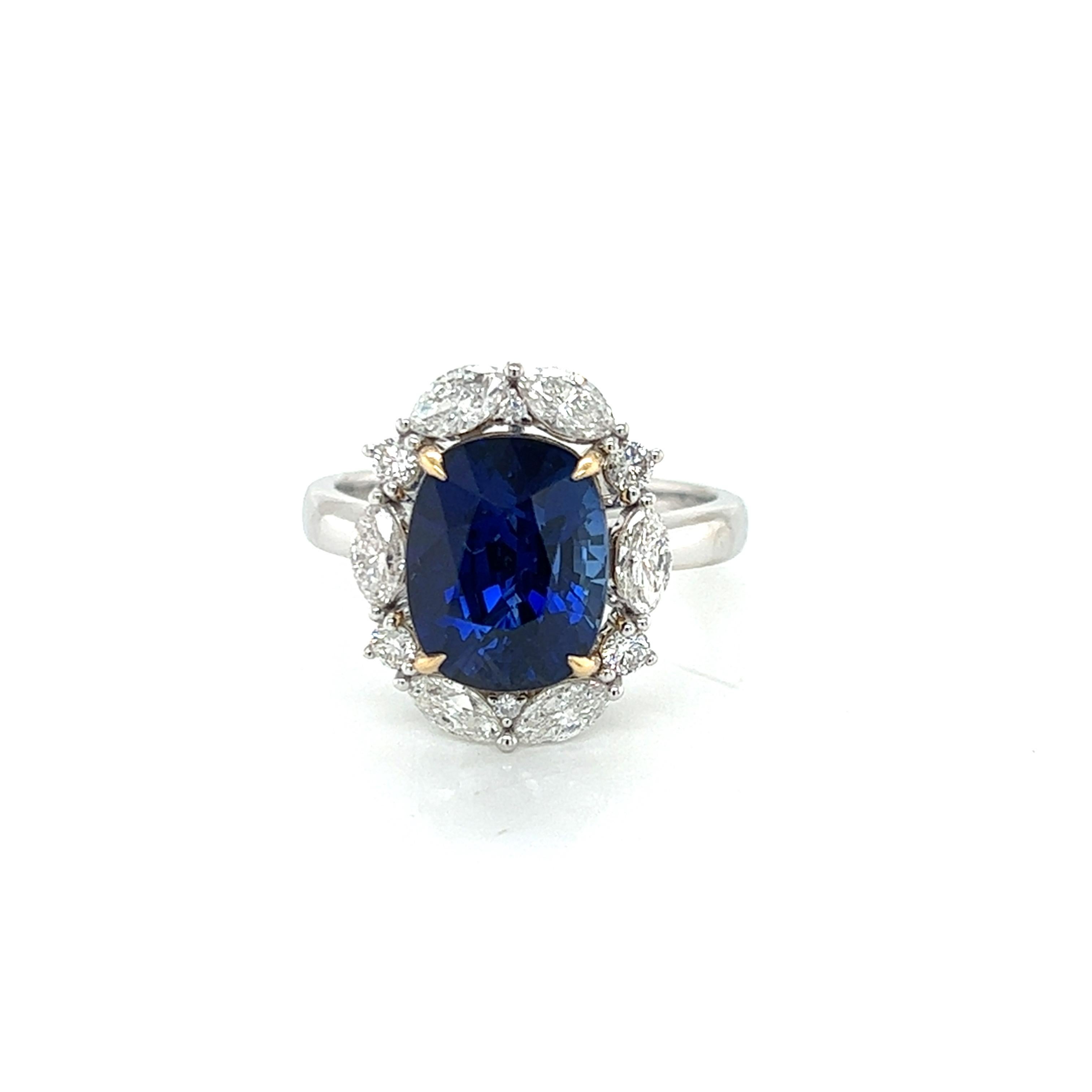 Voici l'époustouflante bague marquise en saphir bleu et diamant de 6 carats, une pièce de joaillerie vraiment exquise qui incarne le luxe et la sophistication. Cette bague est ornée d'un saphir bleu allongé et taillé en coussin, d'un poids
