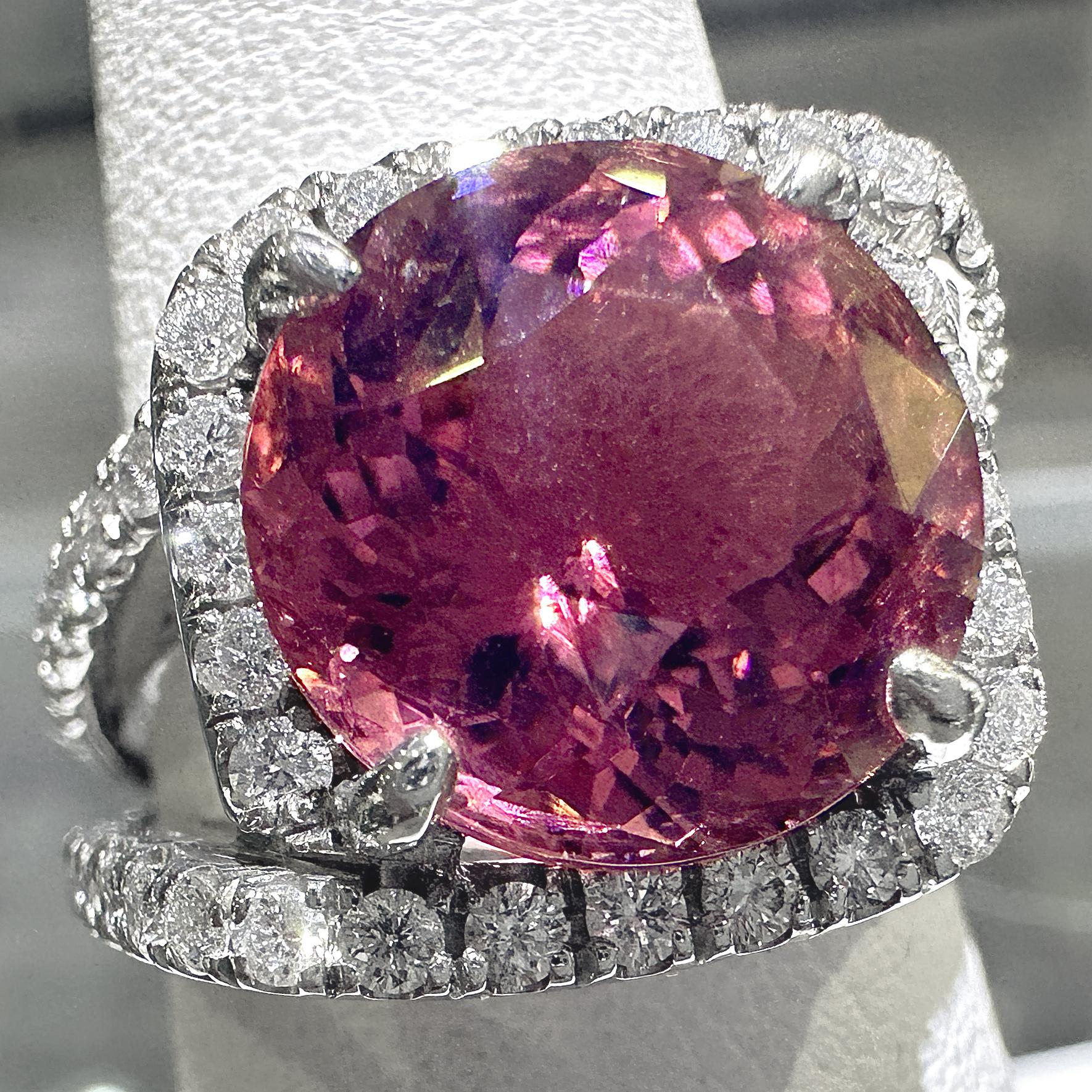Ein atemberaubender und wichtiger neuer Ring von Eytan Brandes zeigt einen zweiteiligen, kissenförmigen Halo aus Diamanten um einen wunderschönen brasilianischen rosa Turmalin.  

Der Turmalin hat einen Durchmesser von 11,7 mm und wiegt 6,08 Karat. 