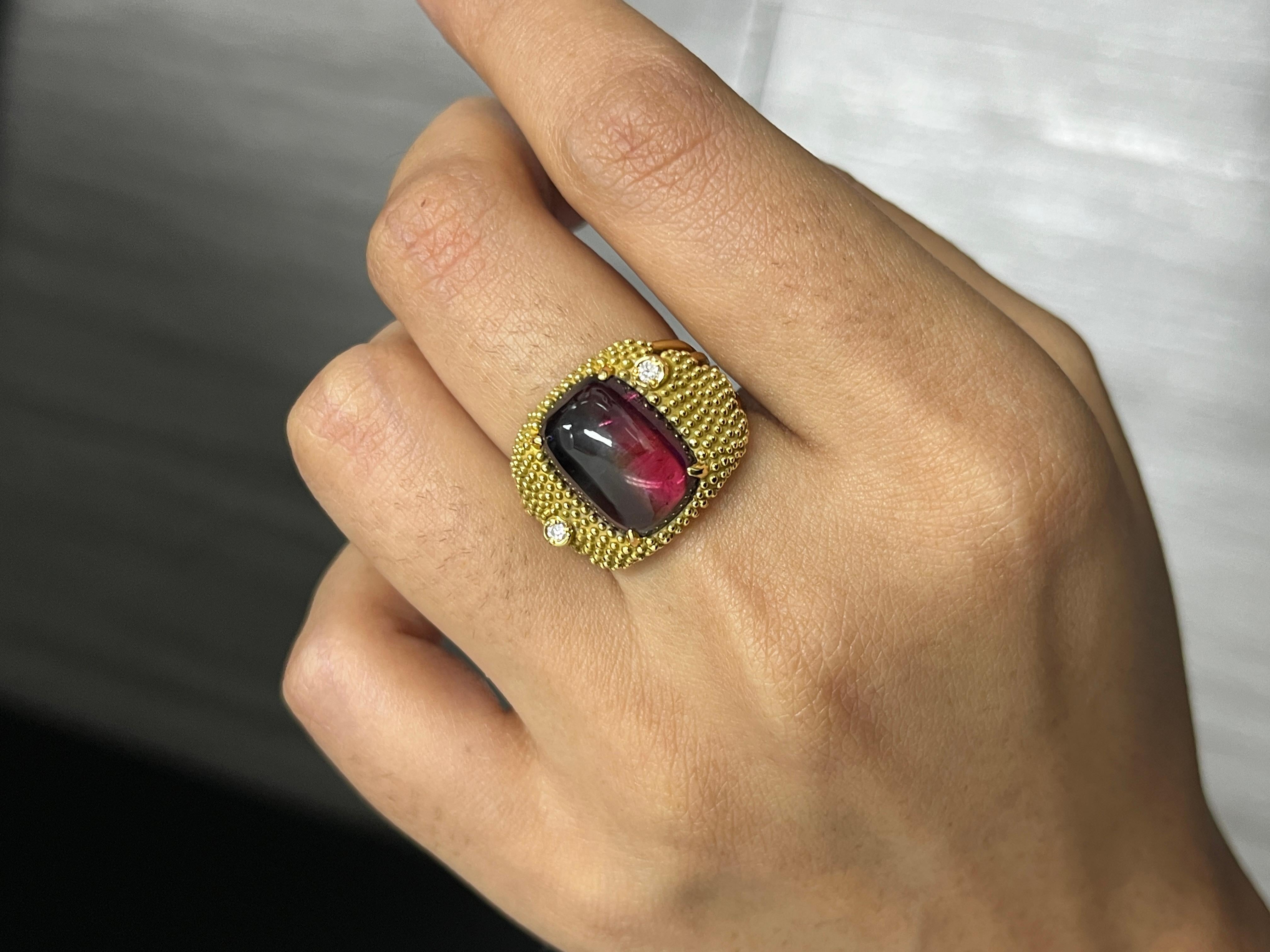 Unser exquisiter 18K Gelbgold Turmalin Statement Ring ist ein wahres Statement für Luxus und Eleganz. Dieses prächtige Stück zeigt einen enormen und atemberaubenden 6-Karat-Cabochon-Turmalin, der zweifarbig ist, ein wunderschönes Ombre von
