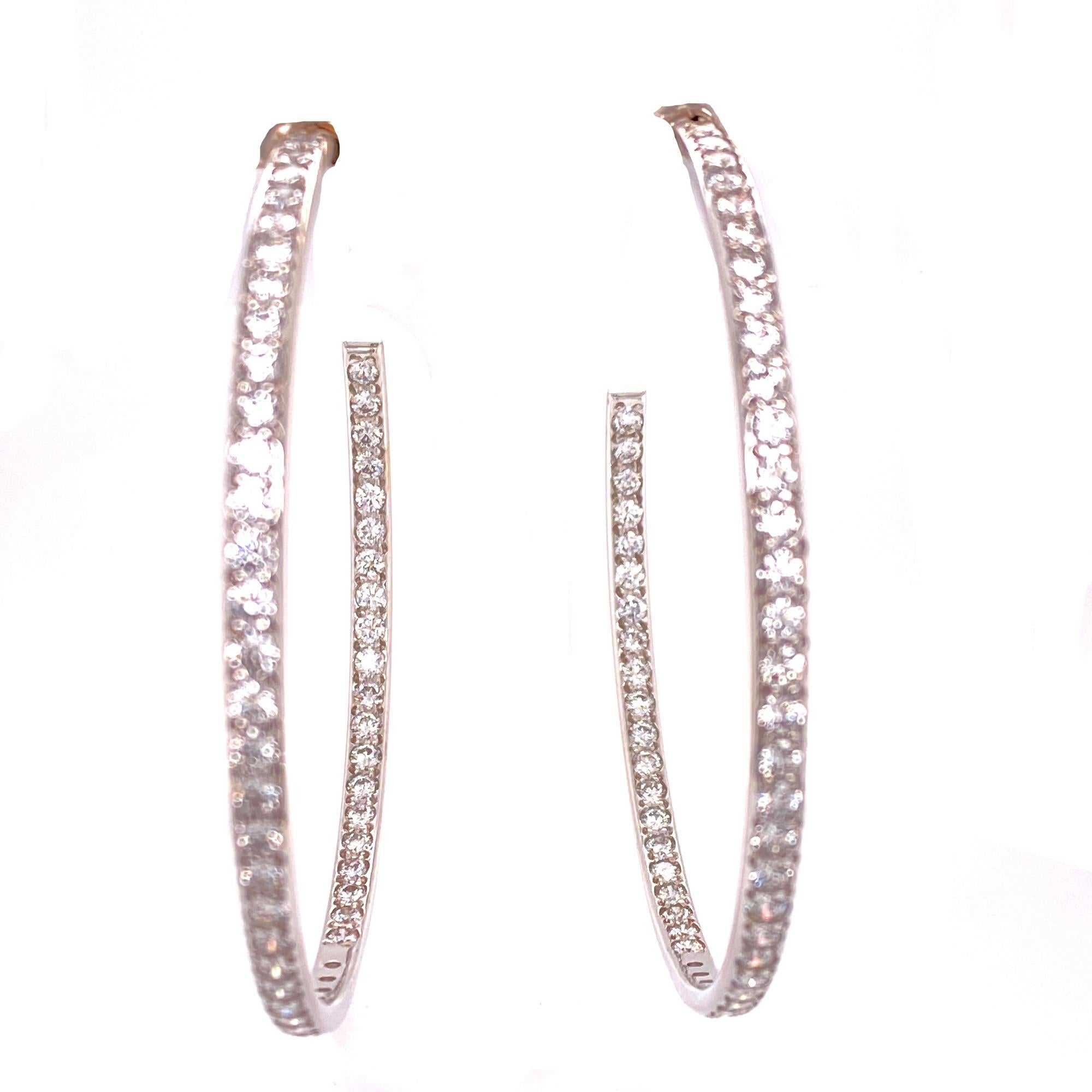 Large Diamond In and Out Hoop earrings fashioned in 18 karat white gold. The earrings feature 6.00 carat total weight of round brilliant cut diamonds graded F-G color and VS clarity. The hoops measure 2 inches in length and width. 