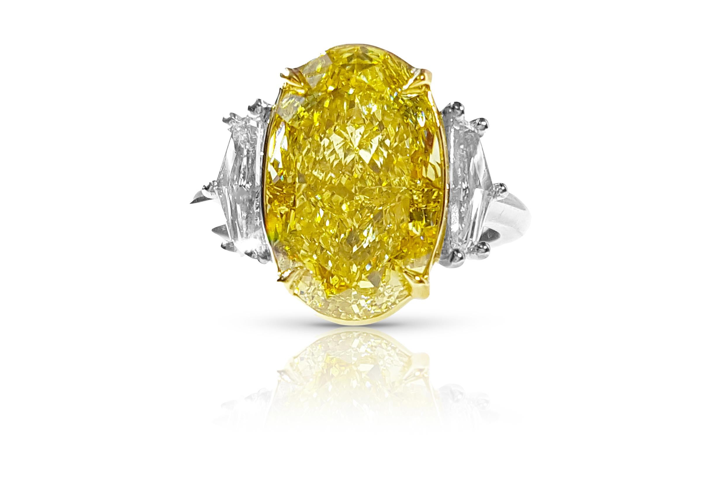 Introducing an Exquisite Three-Stone Engagement Ring showcasing a captivating 6.00-plus carat Fancy Intense Yellow Diamond in a stunning Oval cut. Certified as SI1 by GIA. Enhancing the allure, two Epaulet-cut diamonds accompany the centerpiece,