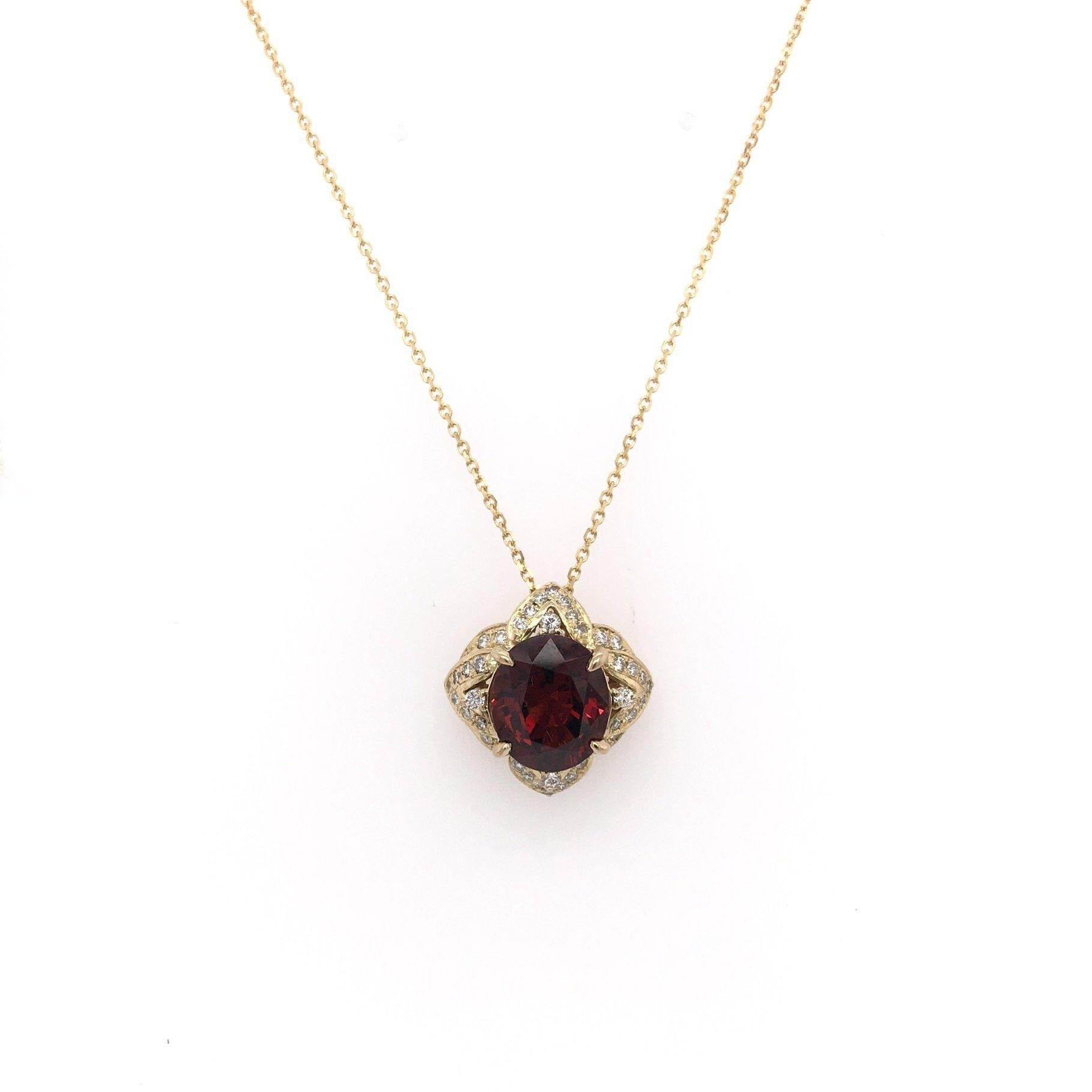This garnet pendant is an estate piece. The central stone is a richly hued garnet. This particular garnet is the classic reddish brown hue most commonly associated with the stone. The center stone measures approximately 6 carats and is a fancy cut.