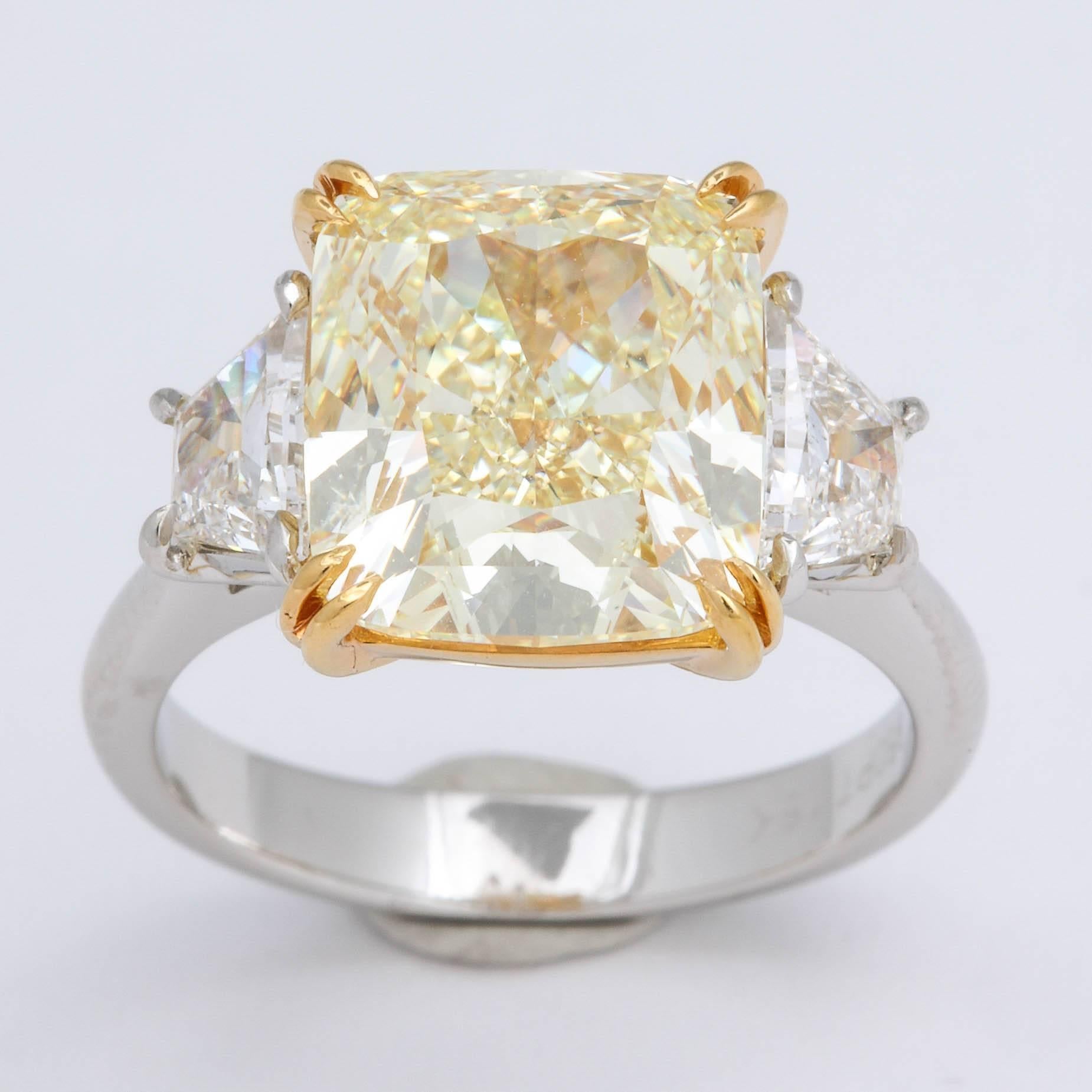 
A FABULOUS RING!!! A BEAUTIFUL ROCK!!

6.28 carats GIA certified Fancy Light Yellow center diamond.

VVS2 clarity -- the diamond is nearly flawless!

The Cushion cut center diamond is set along .81 carats of white, VS trapezoid cut diamonds. 

Set