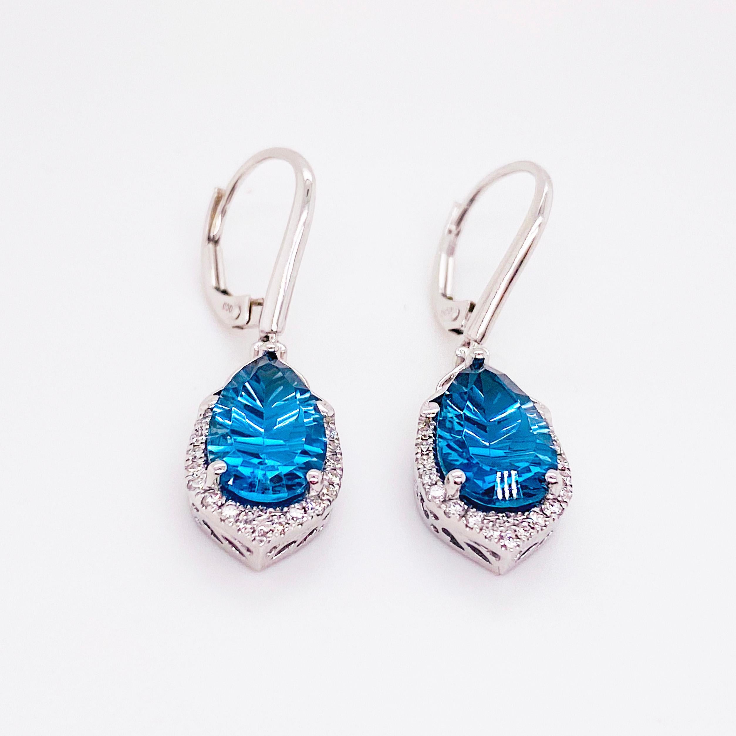 The deep royal London Blue Topaz earrings dangle from a 14 karat white gold with ear wire and the topaz is accented with diamonds around the bottom.  The blue topaz is a fantasy pear cut that are 2.60 carats each with 19 diamonds in each earring.