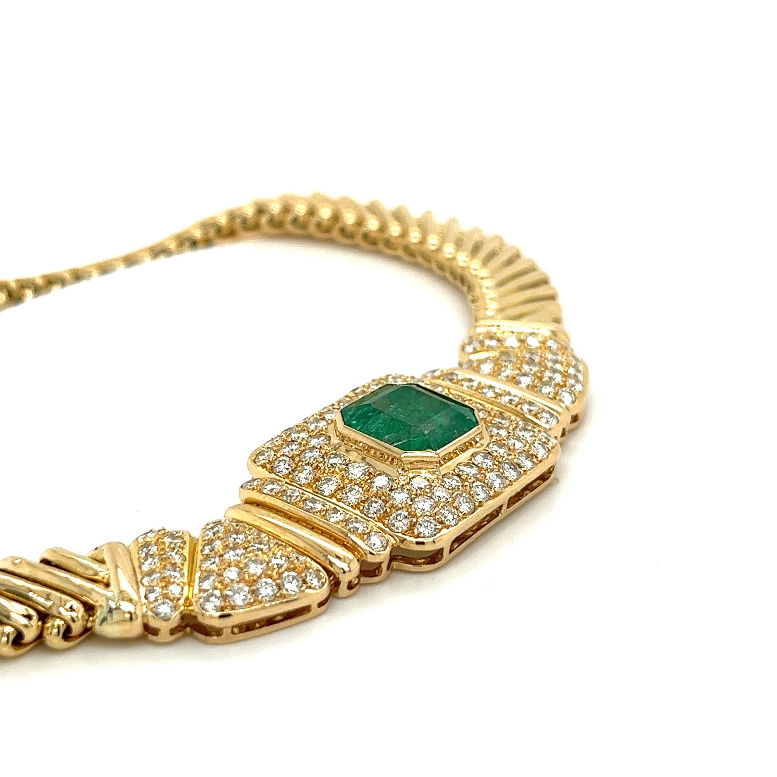 6 carat natural Colombian emerald center stone accentuated by 60 round cut genuine diamonds mounts this stunning ladies' choker necklace. Set in an 18 karat yellow gold flat fancy chain link that sits beautifully on the neck. The center stone is
