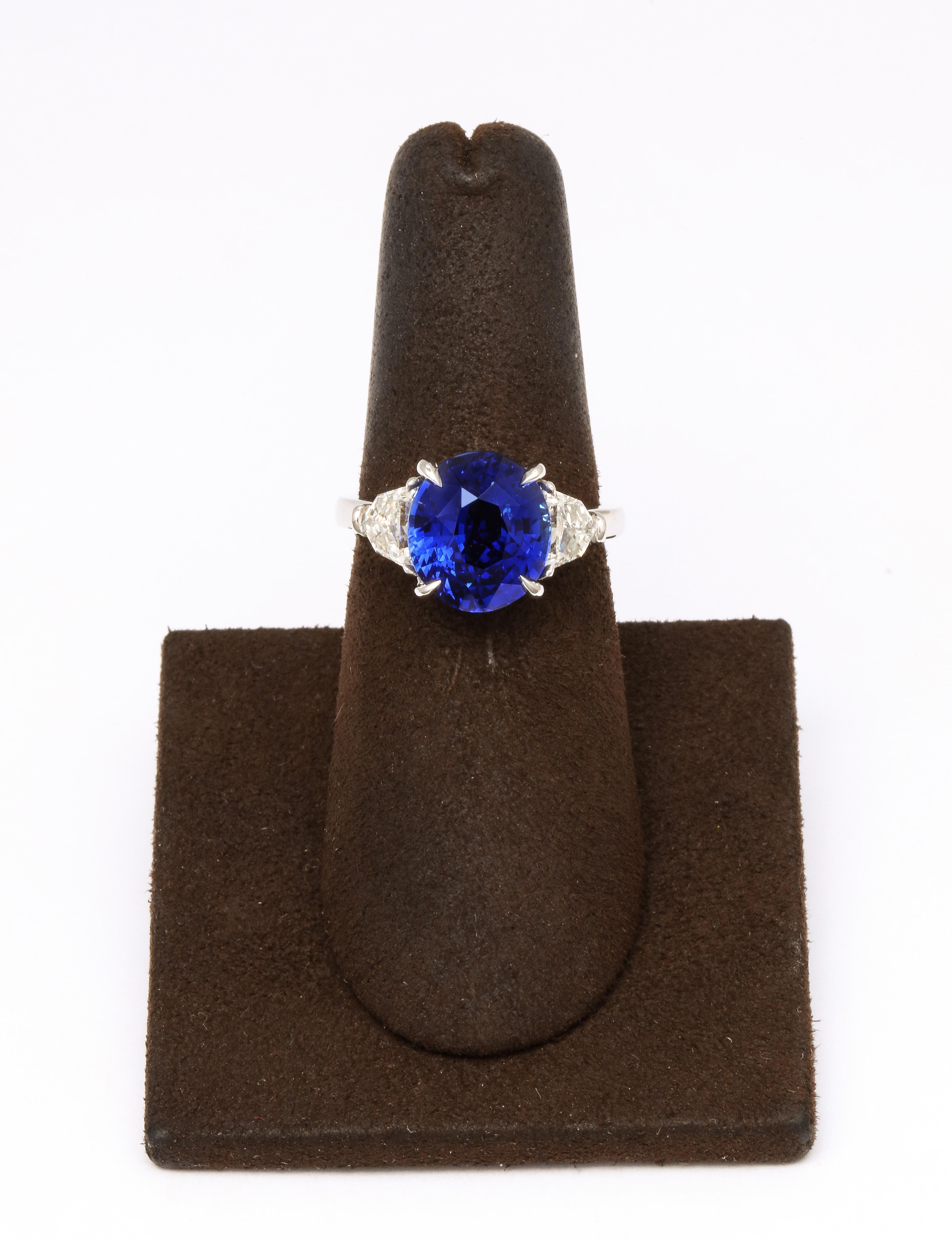 
6.01 carat oval cut certified Ceylon Vivid Blue Sapphire set in a custom made platinum ring with .85 carats of white side diamonds. 

Certified by Christian Dunaigre Lab of Switzerland. 

Currently a size 6.25, this ring can be resized to any