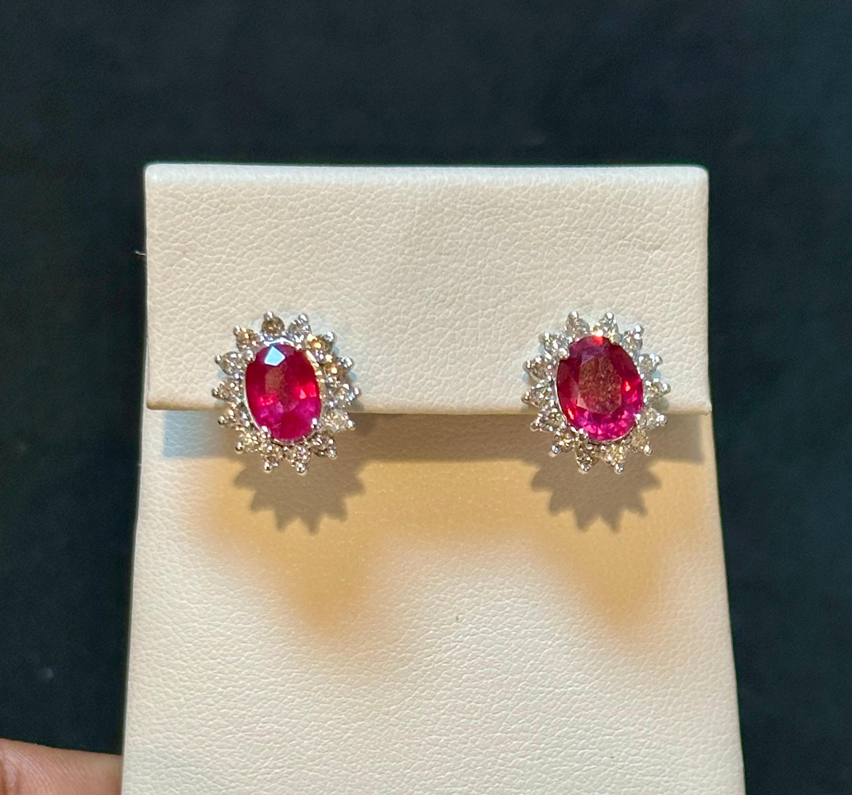 These stunning stud earrings feature a 6 carat oval treated ruby and 1.2 carats of brilliant-cut diamonds. They are meticulously crafted with 14 karat white gold and designed with a post back for secure wearing. The 14K gold used in these earrings