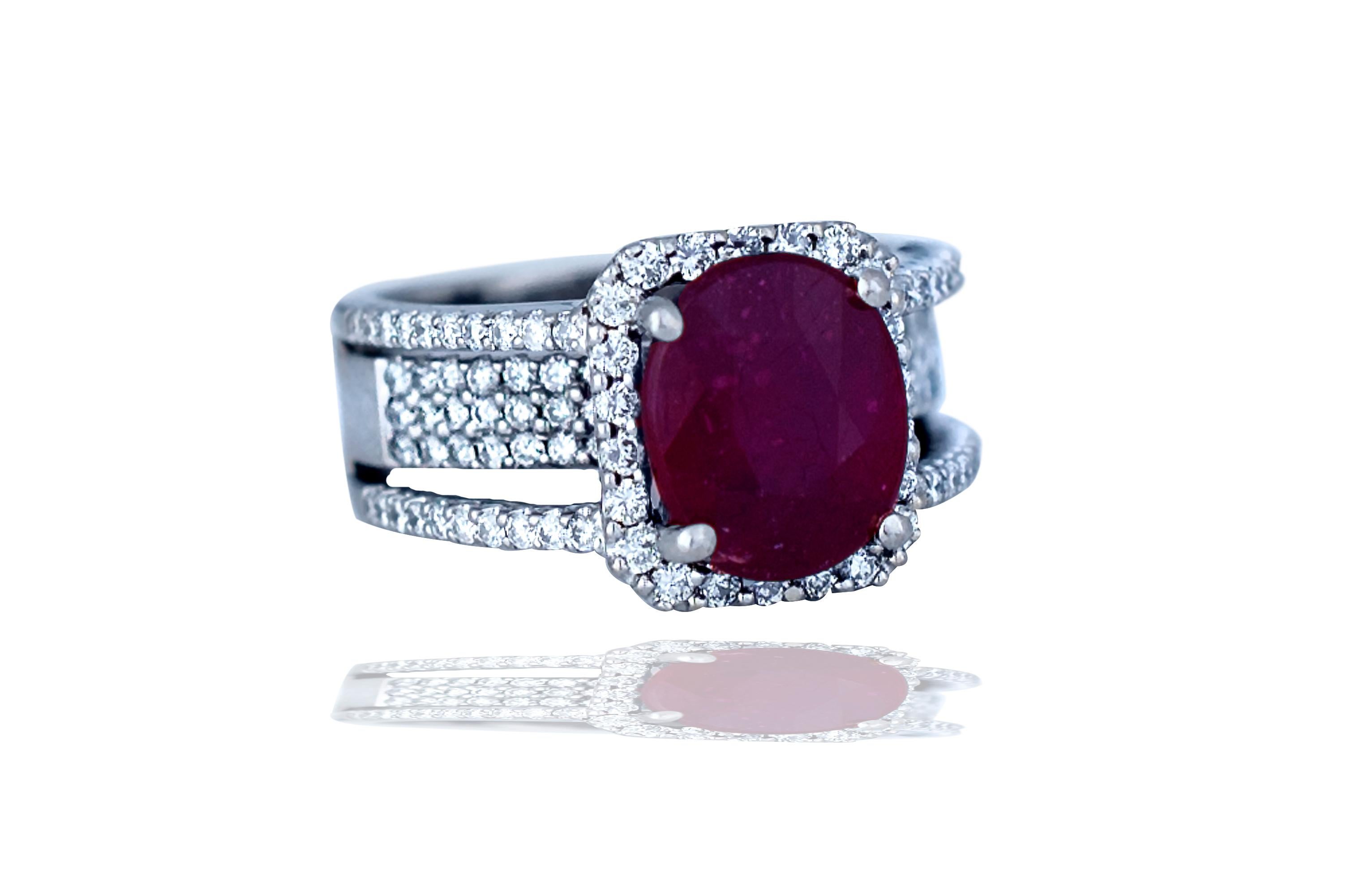 This beautiful red ruby and diamond ring contains the following.  The center stone is apprx. 6 carats and oval in shape and has rich red slightly purple color.  The stone is fairly included as most rubies are.  The center stone is complimented by