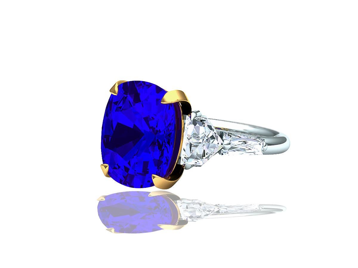 A perfect combination of unique stunning white diamonds contrasted with the deep violet purple blue hues of Tanzanite.  This five stone ring could be imagined in any large jewelry house around the world.  This 6 carat cushion cut Tanzanite has a