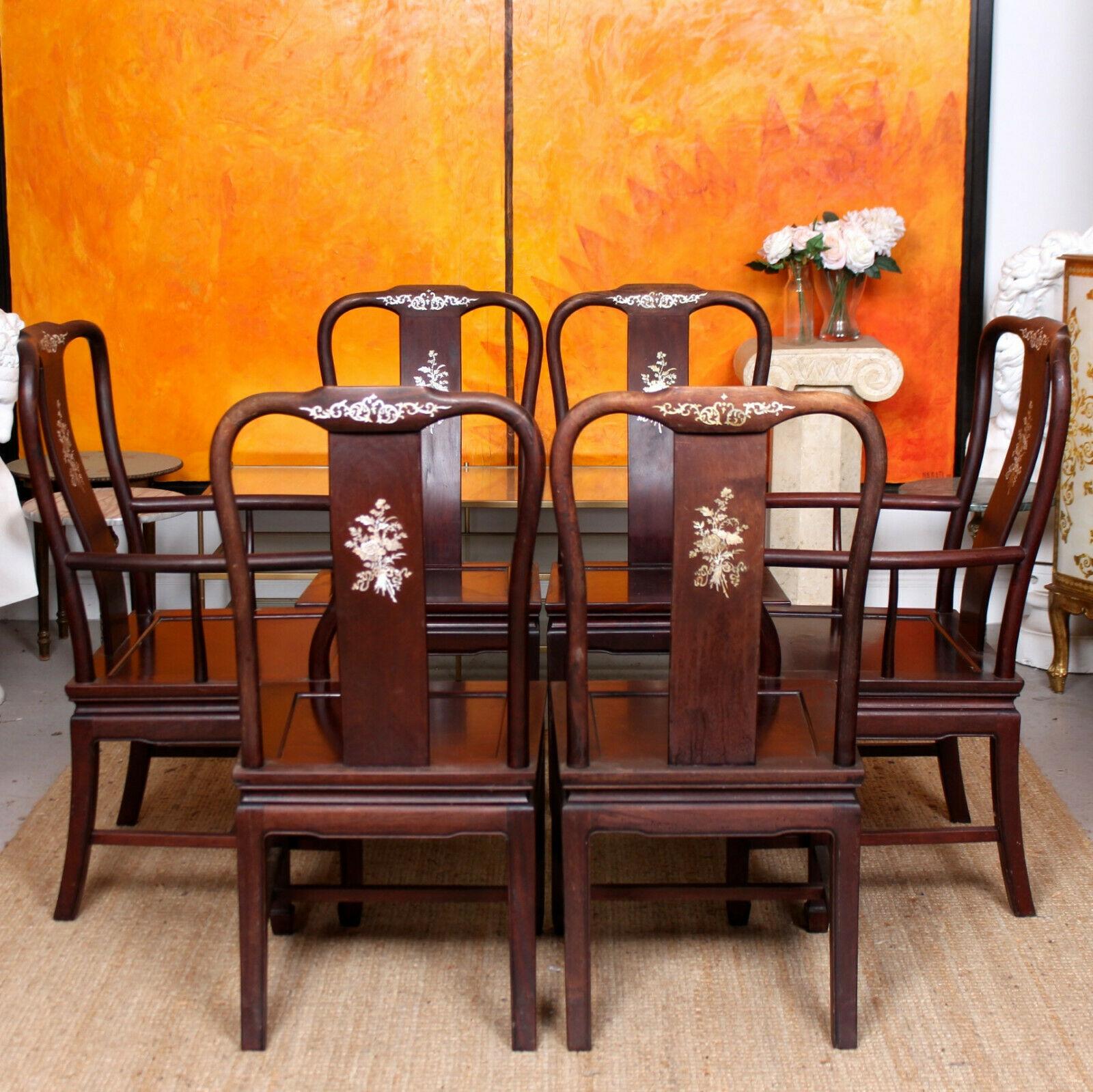 A fine quality set of six mid-20th century Chinese dining chairs.
Constructed from solid Chinese rosewood. The yoked backrests with inlaid mother of pearl decoration above solid paneled seats raised on square and outswept legs with carved feet.