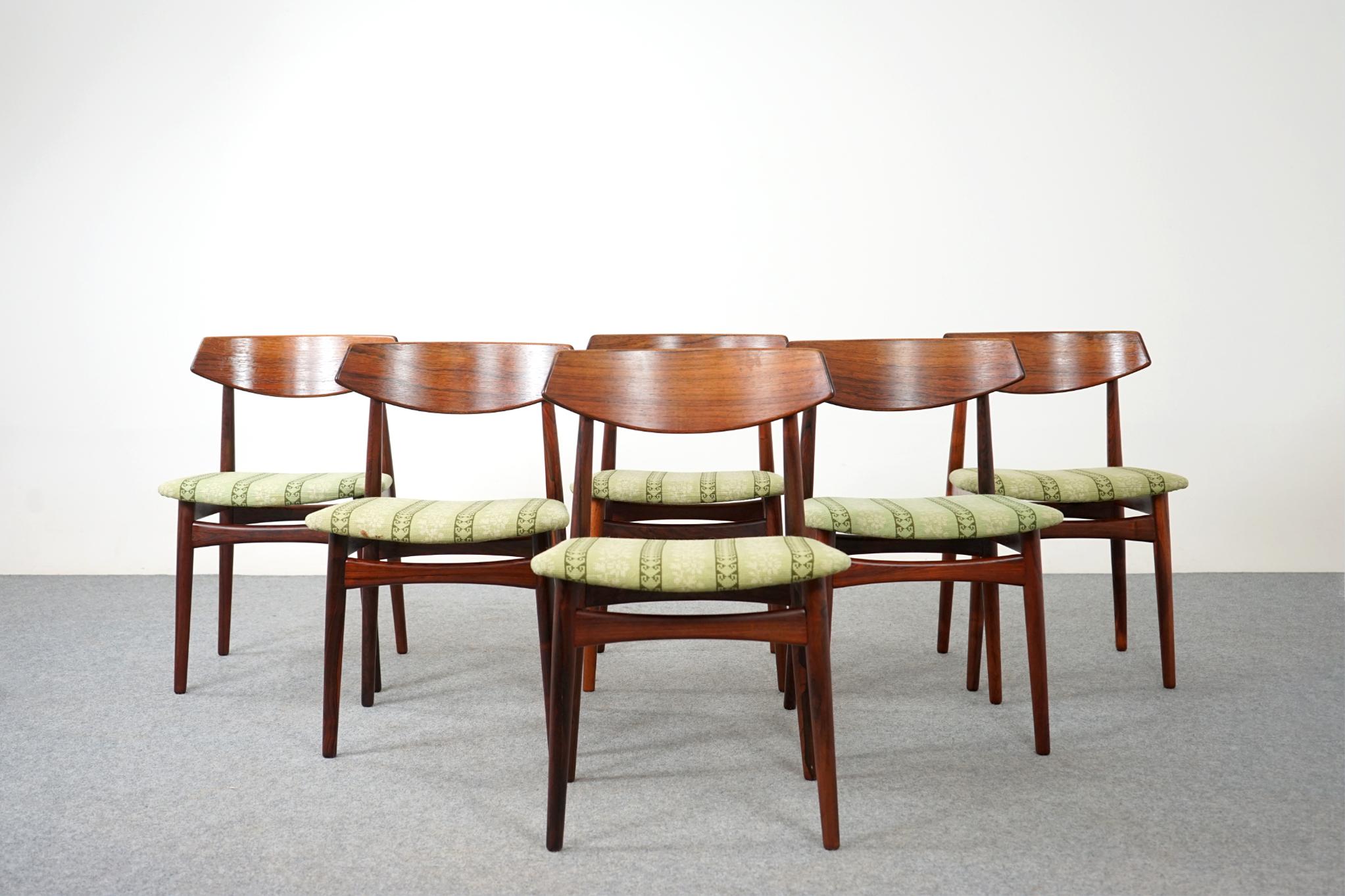 Rosewood mid-century dining chairs, circa 1960's. Beautifully curved backrests provide support and comfort. Generous floating seat design adds an air elegance, lovely bowtie supports for added stability. Original upholstery, removable seat pad makes