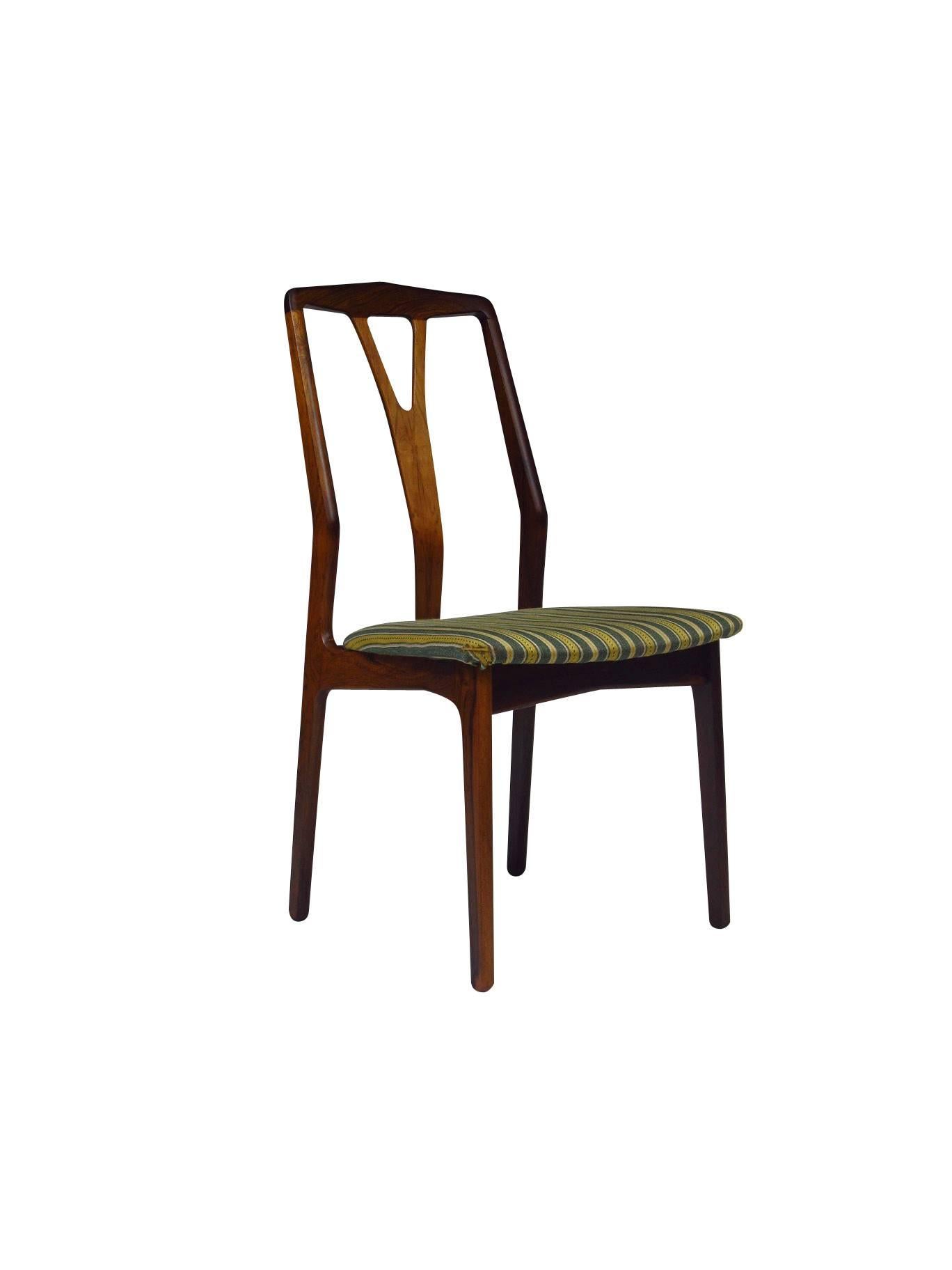 Six Danish rosewood dining chairs with dynamic grained rosewood and hand sculpted wishbone style backs. Original wool upholstered seats can be customized in any fabric or leather of choice.
