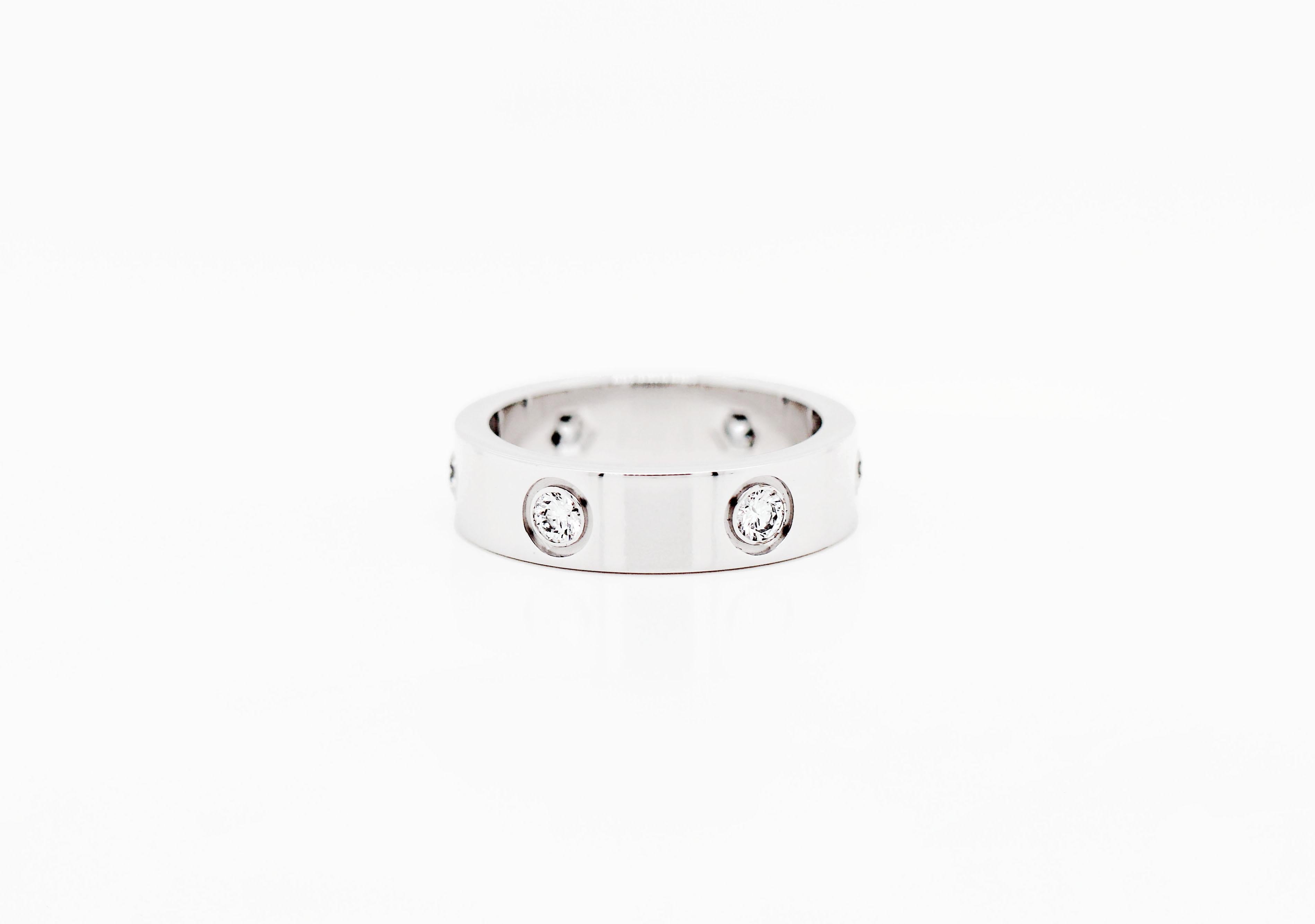 Cartier Love ring set with 6 round brilliant cut diamonds in rub over settings, mounted in an 18ct white gold band. The ring is engraved with the Cartier signature, 750, (size) 54, NT0400. UK finger size 'N'.

Comes with original Cartier box.