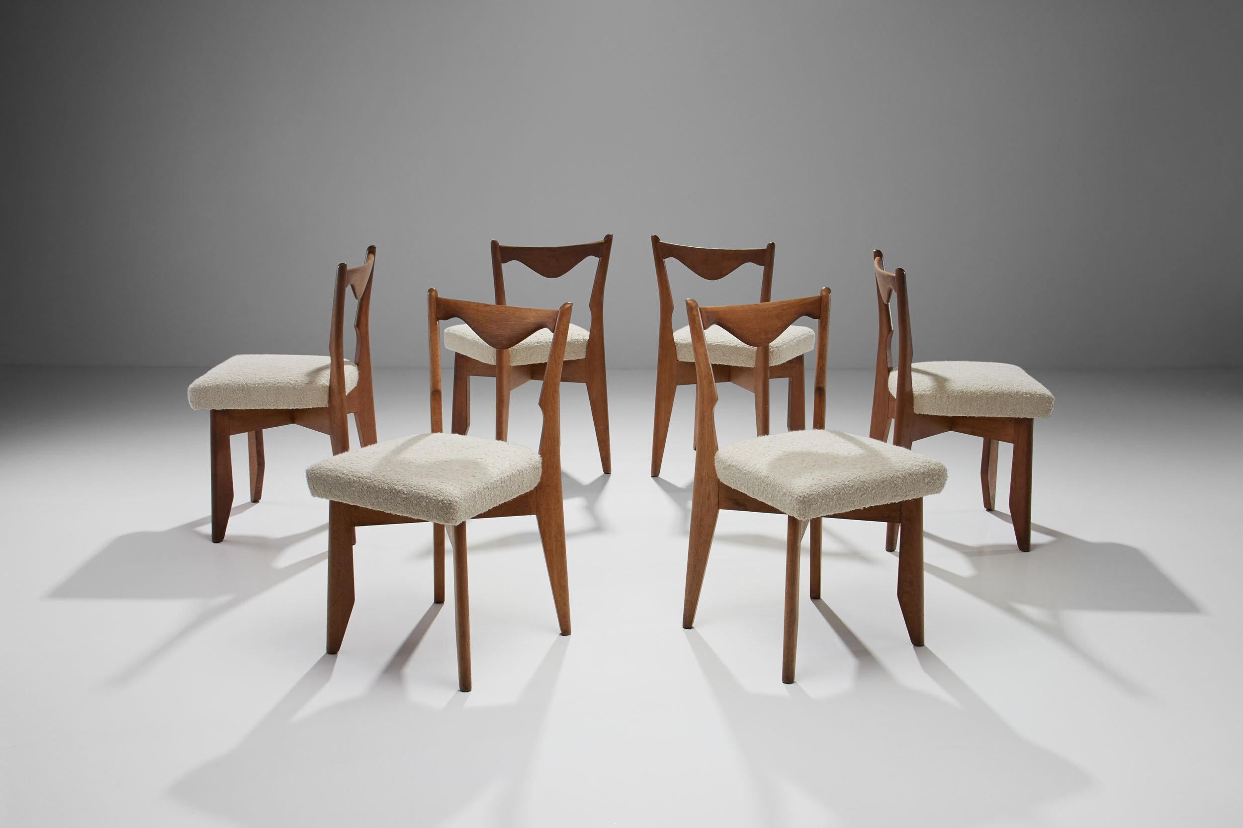 This set of six elegant chairs by the French designers Guillerme et Chambron has a refined and Classic appearance. The chairs feature slightly tilted backrests and distinctive, triangular curved bars. 

The chairs have been reupholstered in a