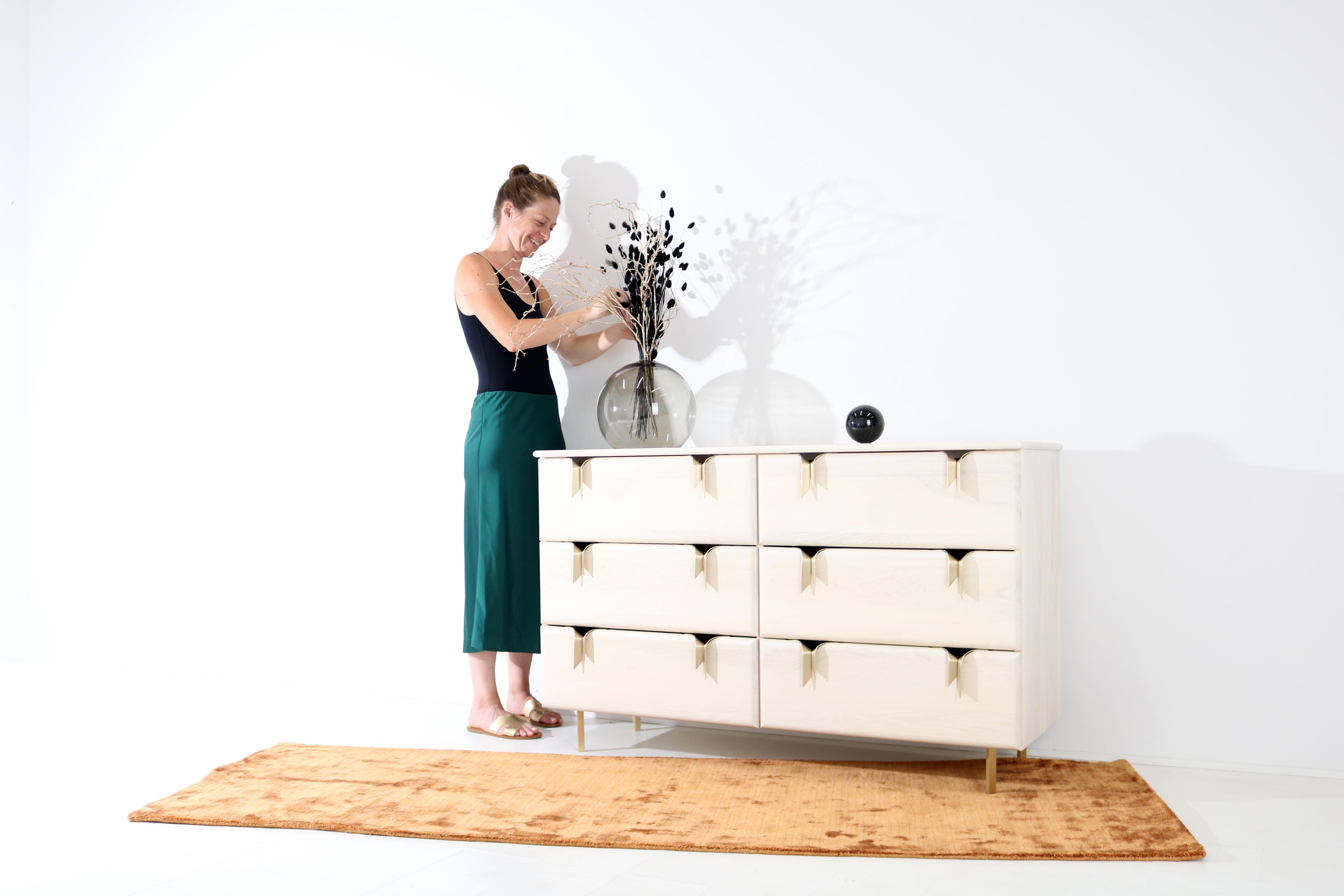An interest in the translation of textile languages and soft surfaces through furniture forms has led to the development of a unique hardware and storage collection. Inspired by ribbons and communicated through hand cast metal hardware and solid