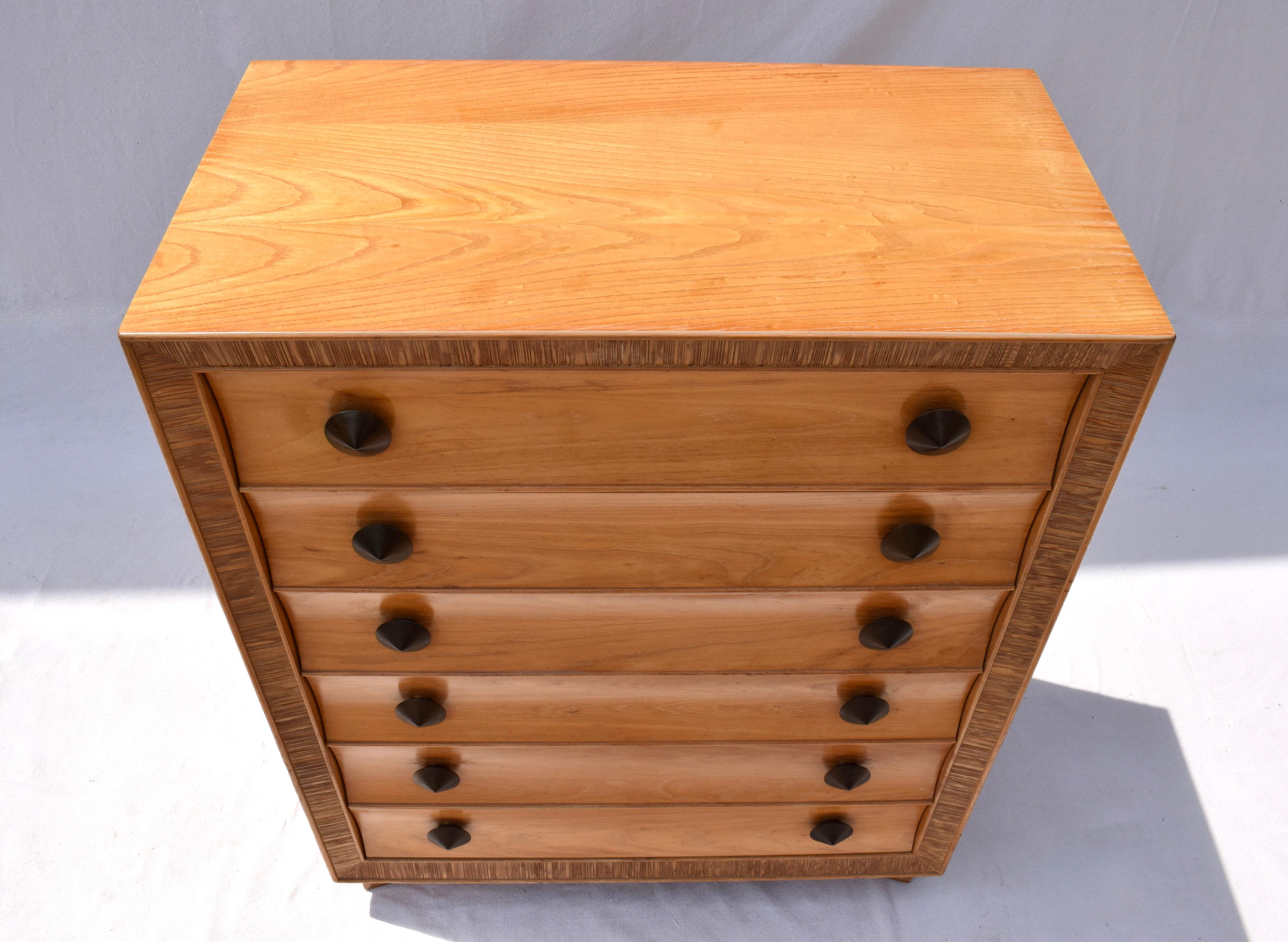 Scarcely seen bleached Oak chest of drawers designed by Paul Frankl for Brown Saltman, California circa. 1940's with logo in the top drawer. Front facing rim is ribbed with concave curved plinth base. Each drawer has 2 patinated brass conical form