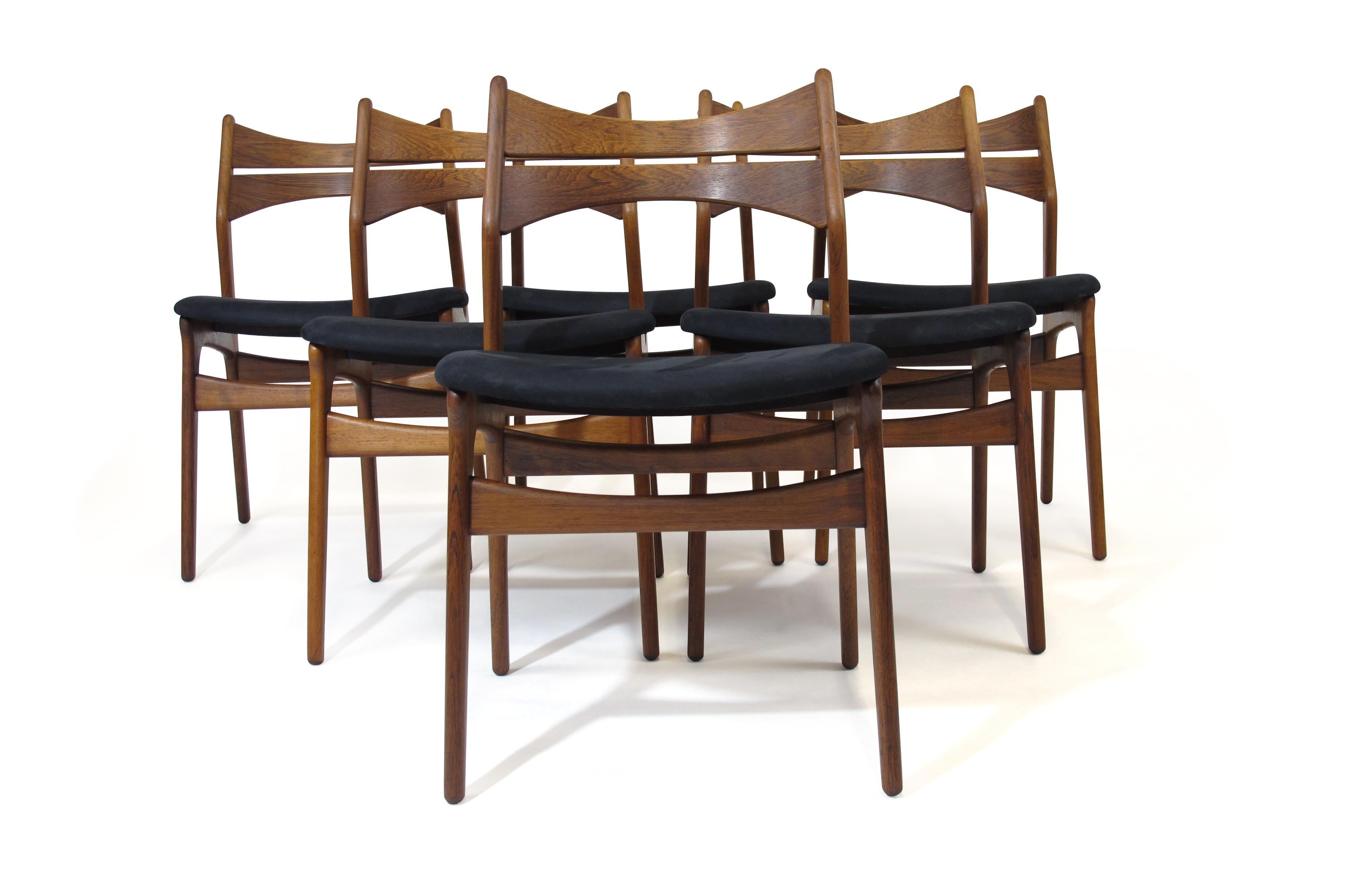 Six Brazilian Rosewood dining chairs designed by Erik Buch for Christensen Denmark, Model 310. Features a solid rosewood frame with comfortable angled back rests. Newly upholstered seats in navy nubuck leather. Chairs are fully restored and in a