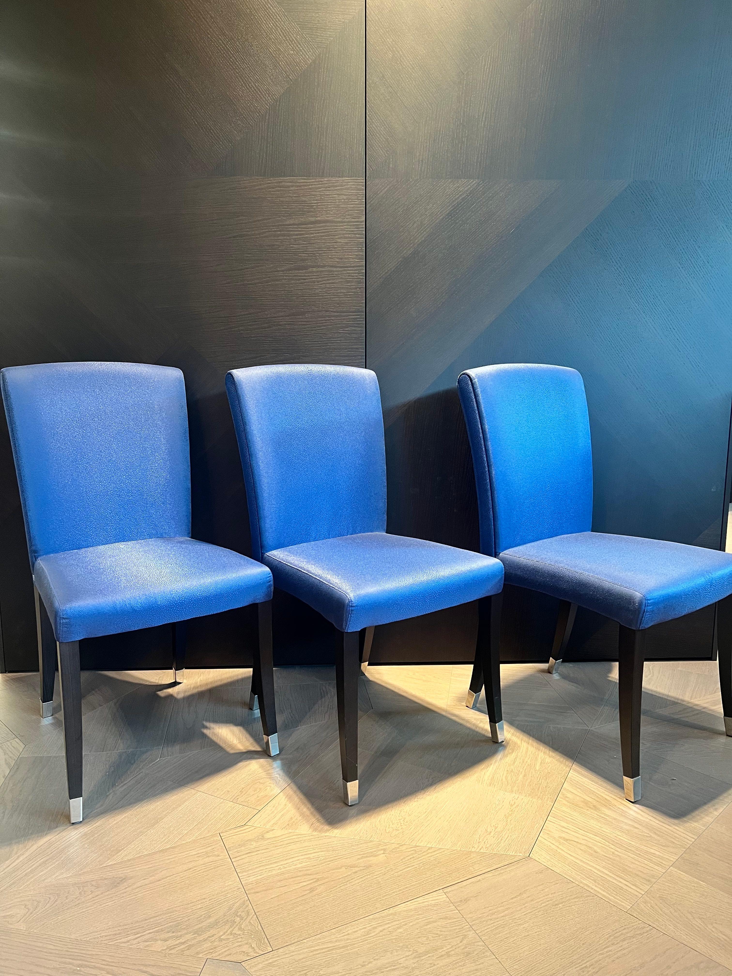 Ce magnifique ensemble de 6 chaises dinging originales FENDI CASA  Les `Elisa` sont très belles et uniques dans leur apparence classique mais moderne. Ils sont recouverts d'un textile de haute qualité bleu légèrement brillant et portent le logo