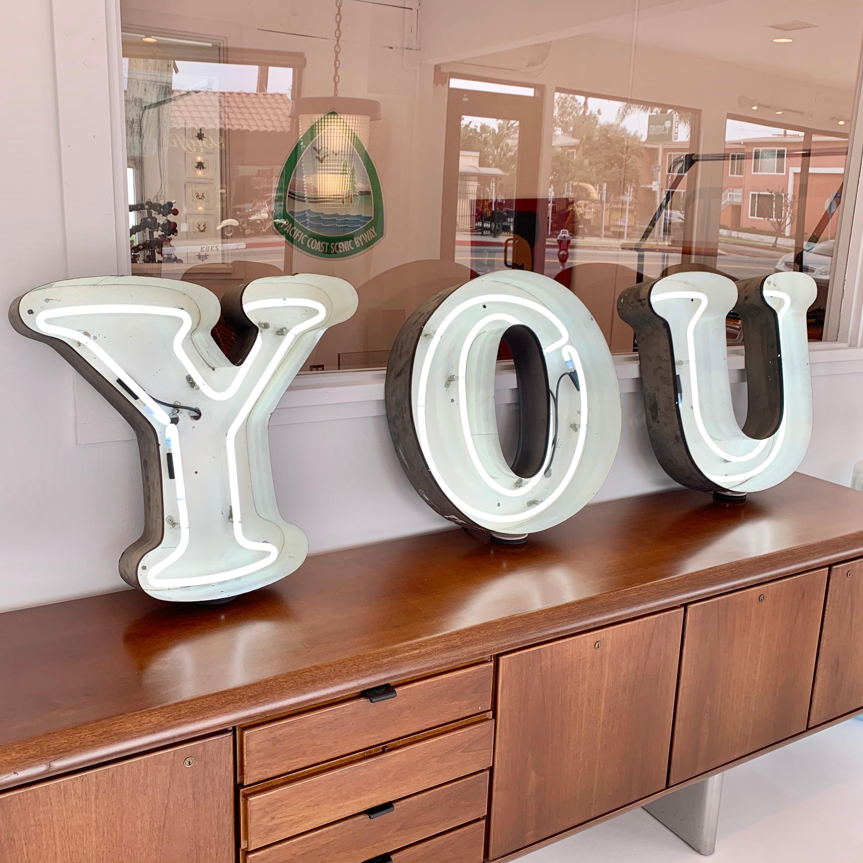 Vintage neon sign, spelling Y - O - U. handcut metal channel letters with hand bent neon glass. Just over 6 feet long when lined up horizontally. Double row of neon inside each letter. Black letters with white inside. All newly rewired, and newly
