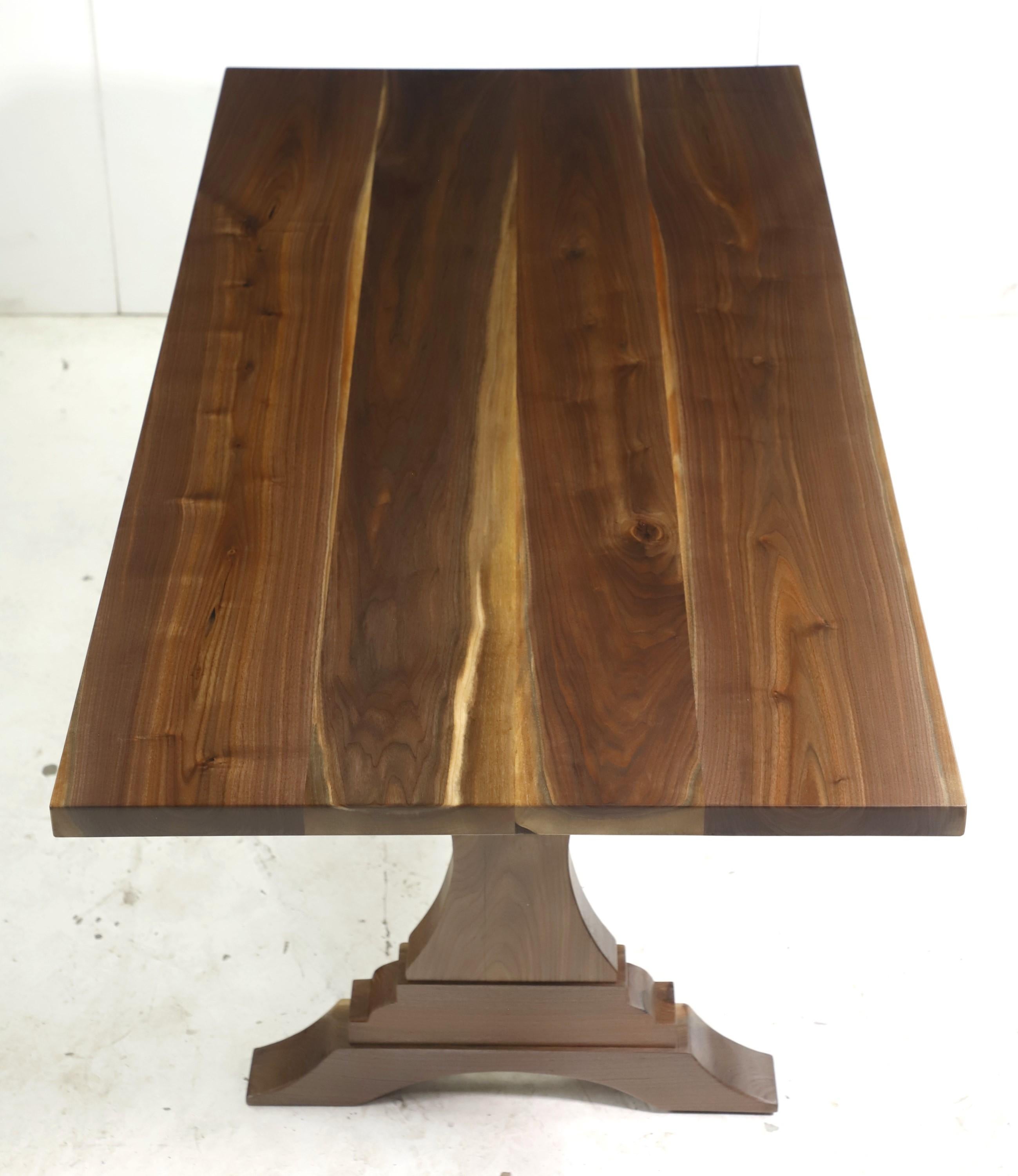 This dinging harvest farm table features a four slab solid walnut top paired with trestle legs. This table is ready to ship. Please note, this item is located in our Scranton, PA location.