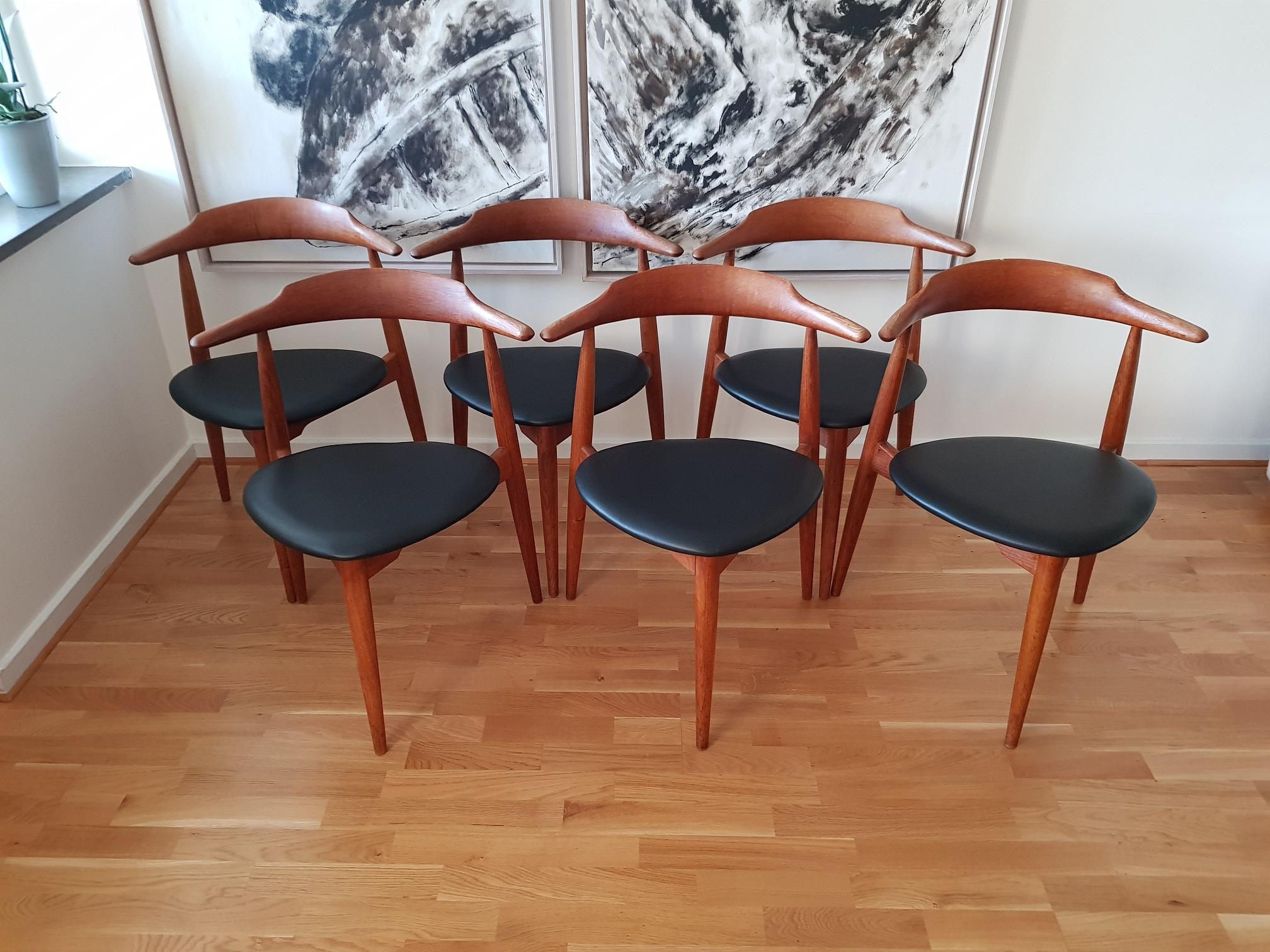 6 vintage Heart chairs in oiled teak/oak and black leather. Newly upholstered in black leather. The chairs were produced in the 1960s and are just stunning. Hans J. Wegner is one of the most famous Scandinavian furniture designers and he made iconic