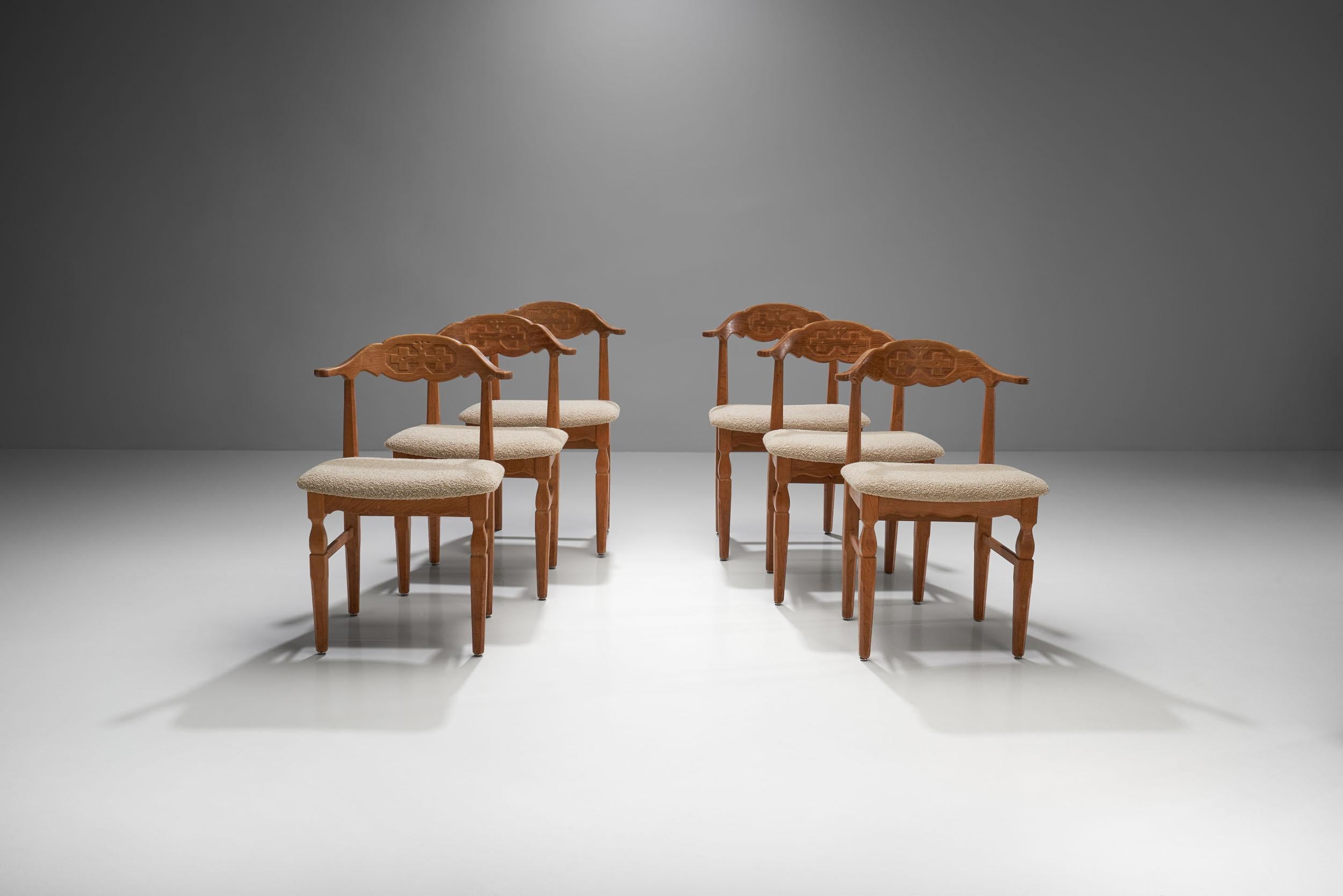 Designed by Henning Kjærnulf, Denmark 1960s. This set of six oak chairs have a curved backrest and display Kjærnulf’s distinctive rustic yet modern style. The chairs have carved details on the backrest and the legs that further add to their unique