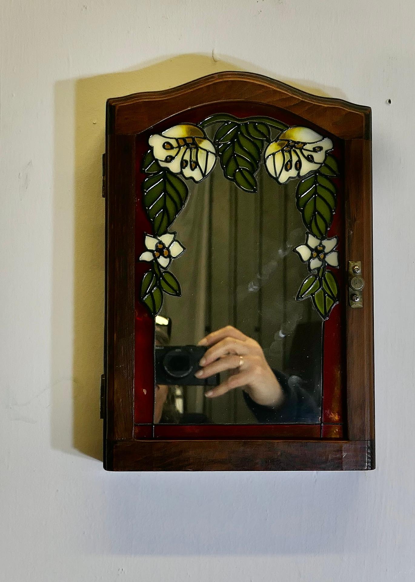 Armoire à clés à 6 crochets  

Une petite armoire à clés à façade en miroir avec décoration en verre coloré et 6 crochets à l'intérieur.
L'armoire est en bon état,  Il mesure 17