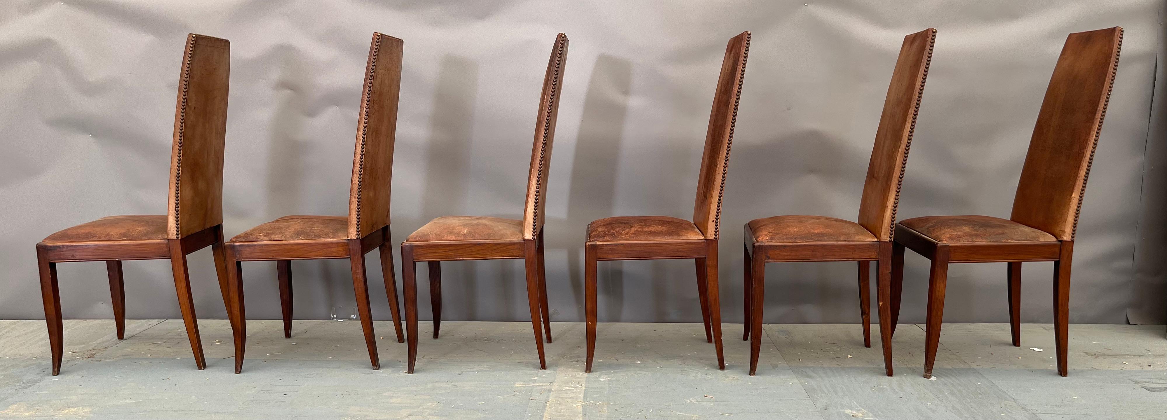 Set of six beautiful leather and wood chairs with beautiful patina to the leather and nailheads. These chairs were found in France and have been invited to many dinner parties - if only they could talk! These pieces would blend beautifully in a