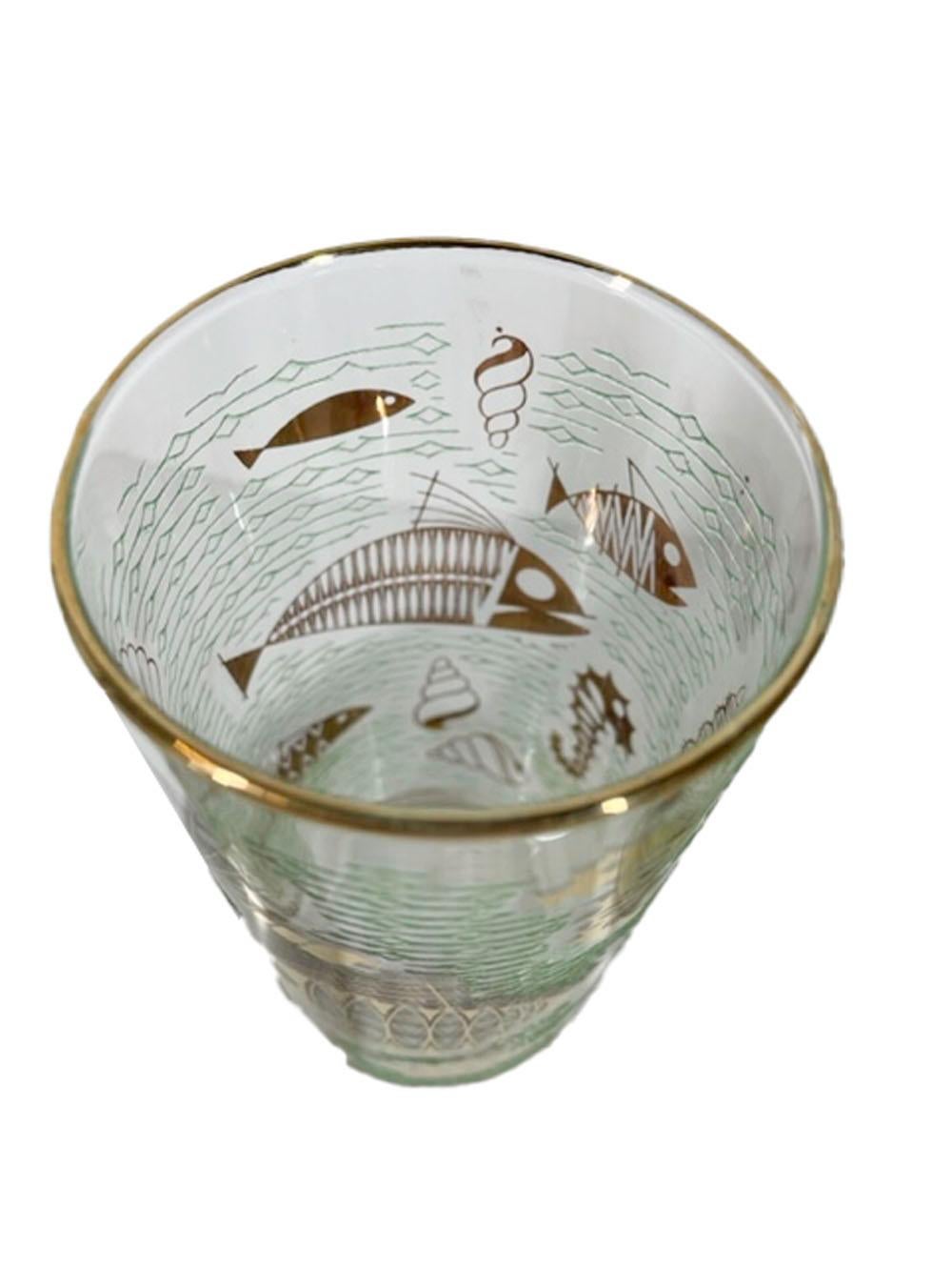Six mid-century modern highball glasses by Libbey Glass in the Marine Life pattern with 22k gold stylized fish and other marine animals against a ground of raised translucent green enamel waves.