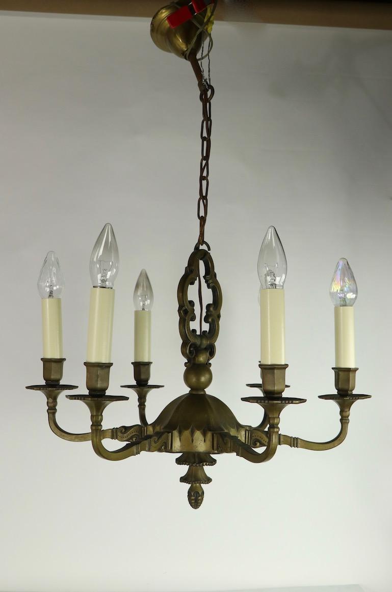 Exquisite cast bronze American Art Deco six-light chandelier having a solid cast bronze body with distinctive Art Deco castings. Each arm projects 8 inches from the center and supports the uplight candle sleeve. Probably American made in the French