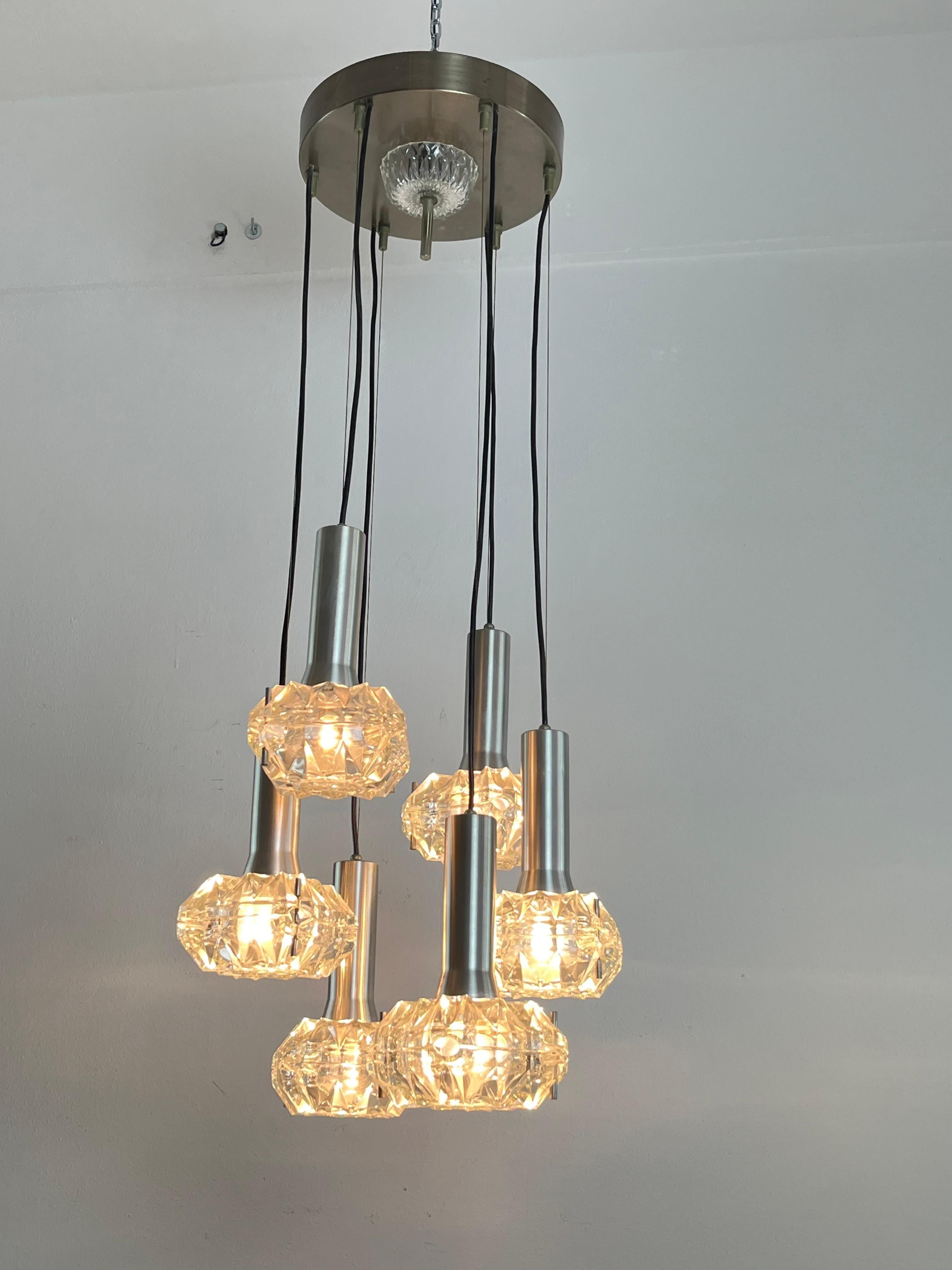 Araña de 6 luces en cascada de acero y cristal, años 70, diseño italiano.
Intacto y en funcionamiento. Lámparas E27.
Buen estado, pequeños signos de envejecimiento.

Garantizamos un embalaje adecuado y realizaremos el envío a través de DHL,