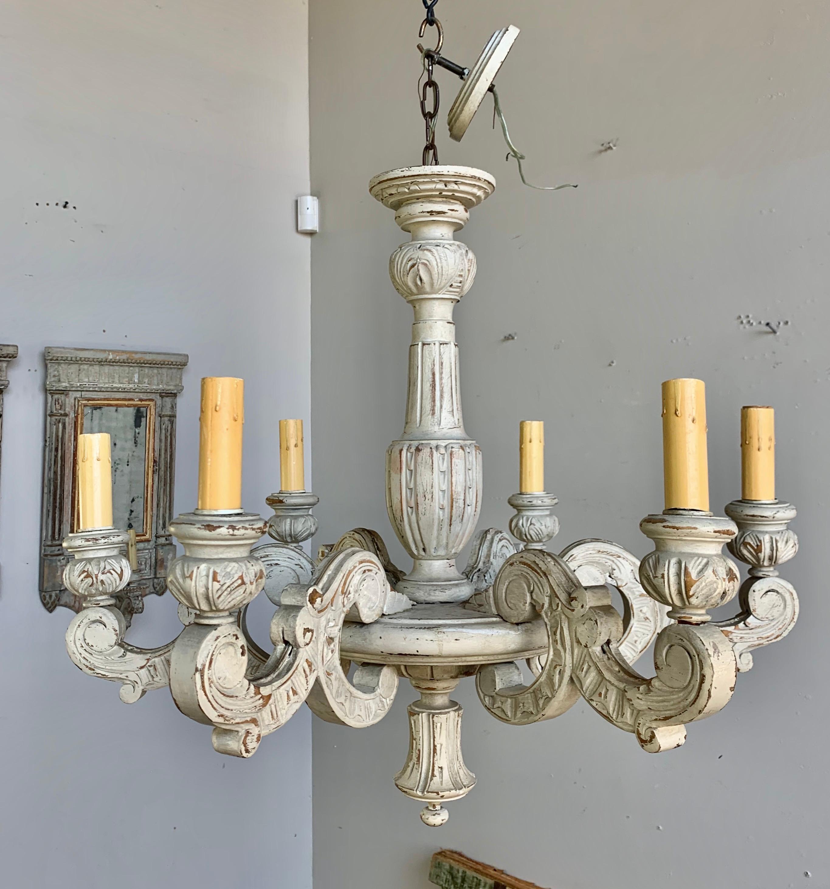 Italian six-light carved wood cream colored chandelier. The fixture has been newly rewired with parchment candle covers and is ready to install with chain and canopy.