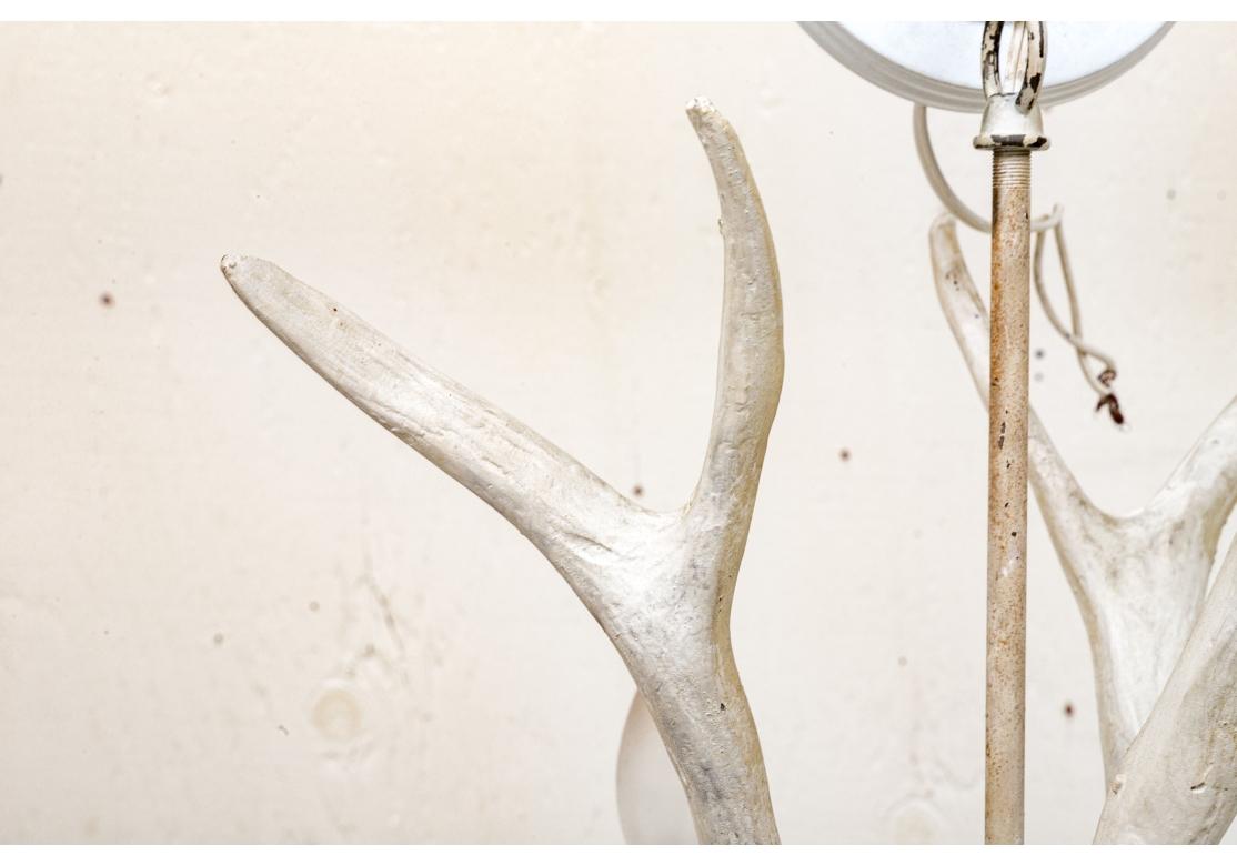 Un lampadario a sei luci a forma di corno bianco collegato a un'asta standard dipinta. Con un terminale a forma di piatto al centro e una piastra da soffitto in metallo bianco con una catena. Il tutto con una finitura bianca anticata che è stata