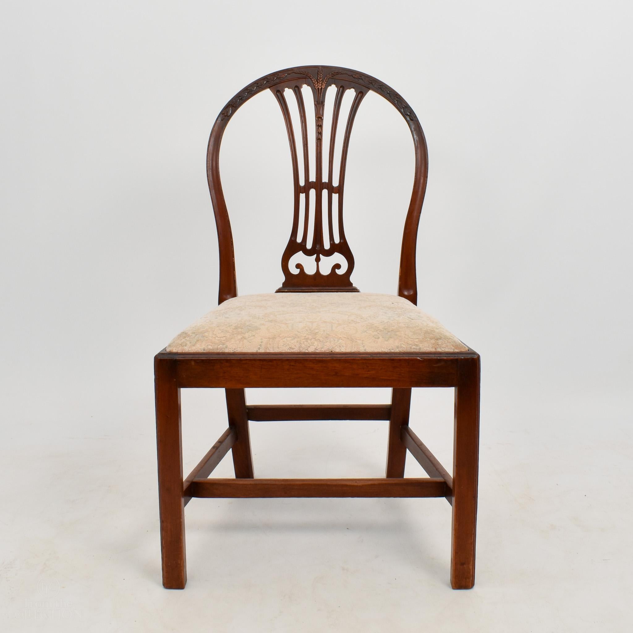 Set of 6 mahogany Hepplewhite dining chairs with wheat carving to the backs. The wood is beautifully rich and all of the chairs are in good condition. Some of the fabric on the seats could do with some upholstery, but we can arrange this before
