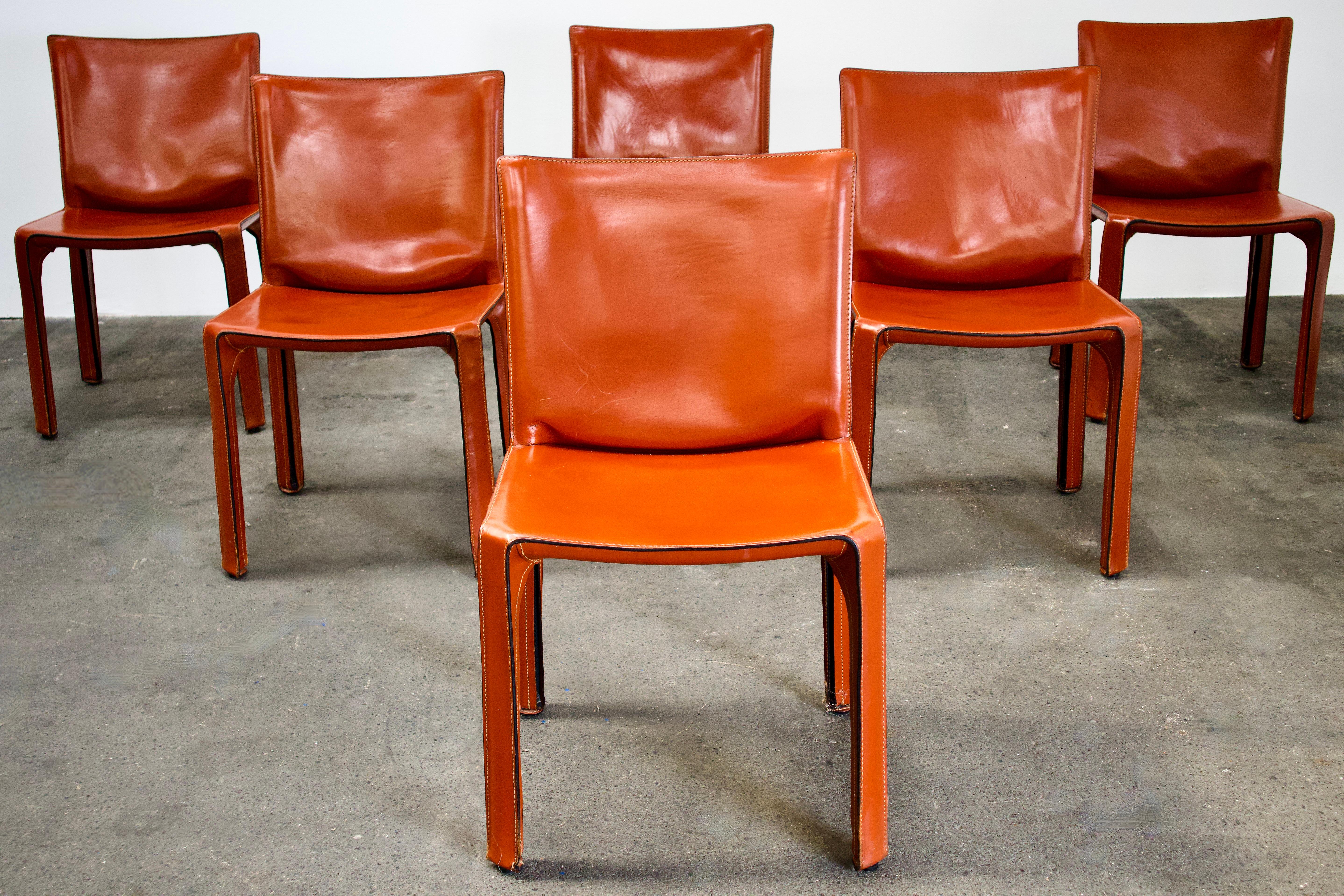 Set of 6 Mario Bellini CAB 412 chairs, made by Cassina in the 1980s. Flexible steel frame covered with a skin of high quality Russian Red (also known as Bulgarian Red) saddle leather. This elegant, versatile chair is equally suitable for the dining