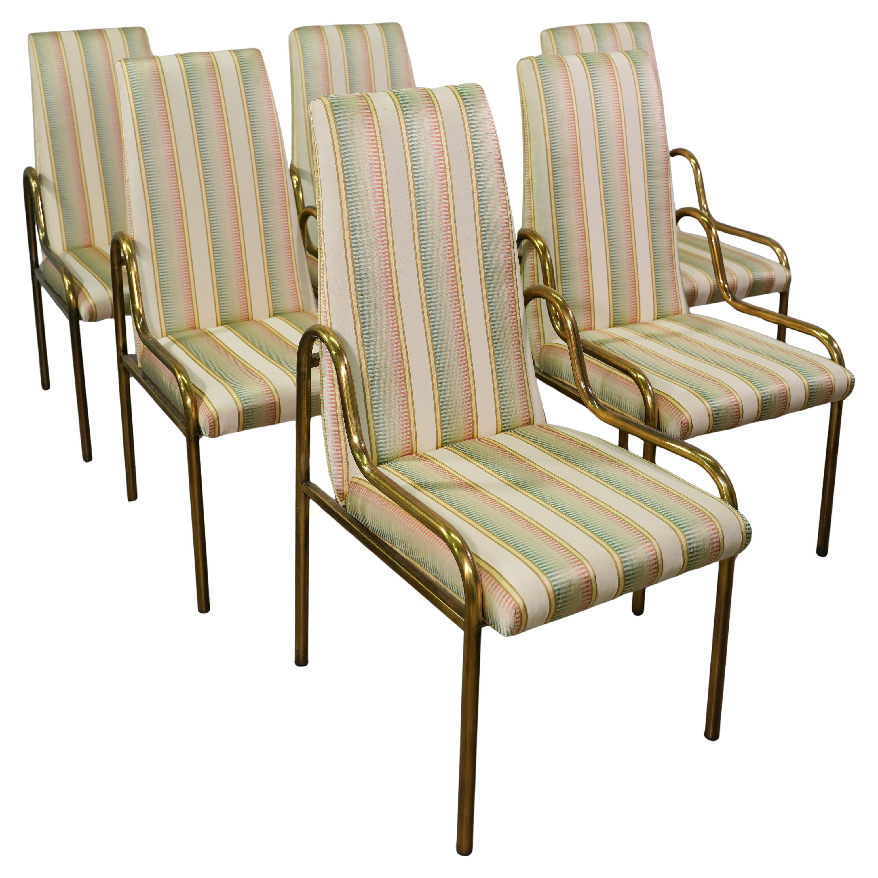 An exceptional set of six Mid-Century Hollywood Regency brass dining chairs by Mastercraft. The chairs feature sculpted tubular brass frames with an Art Deco aesthetic.