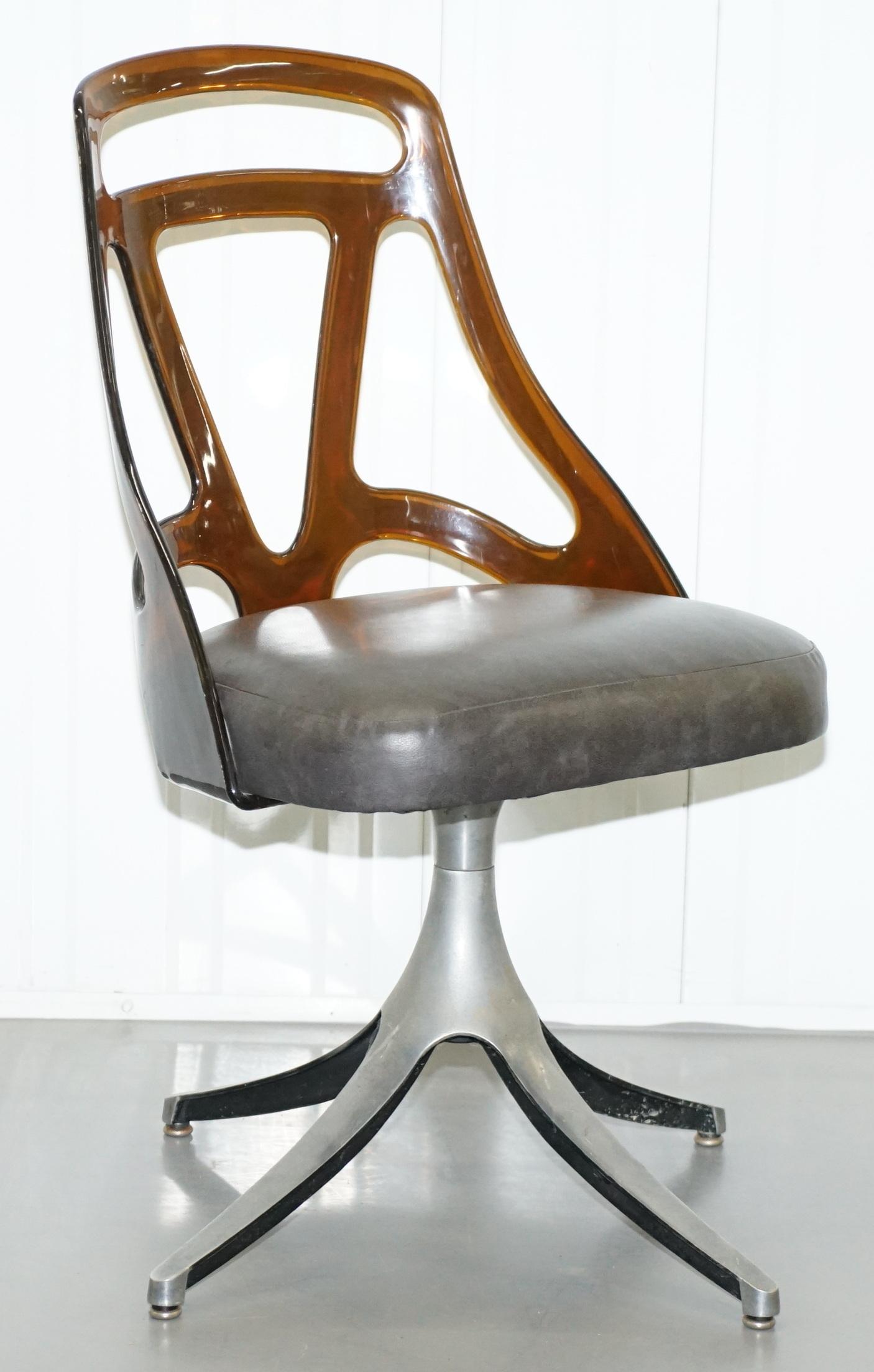 We are delighted to offer for sale this lovely set of six Grafton w1s stamped est 4001 model dining chairs circa 1960

A very cool and decorative set of chairs, they have Perspex backs, leather seats and solid steel sculptural bases. Each chair is