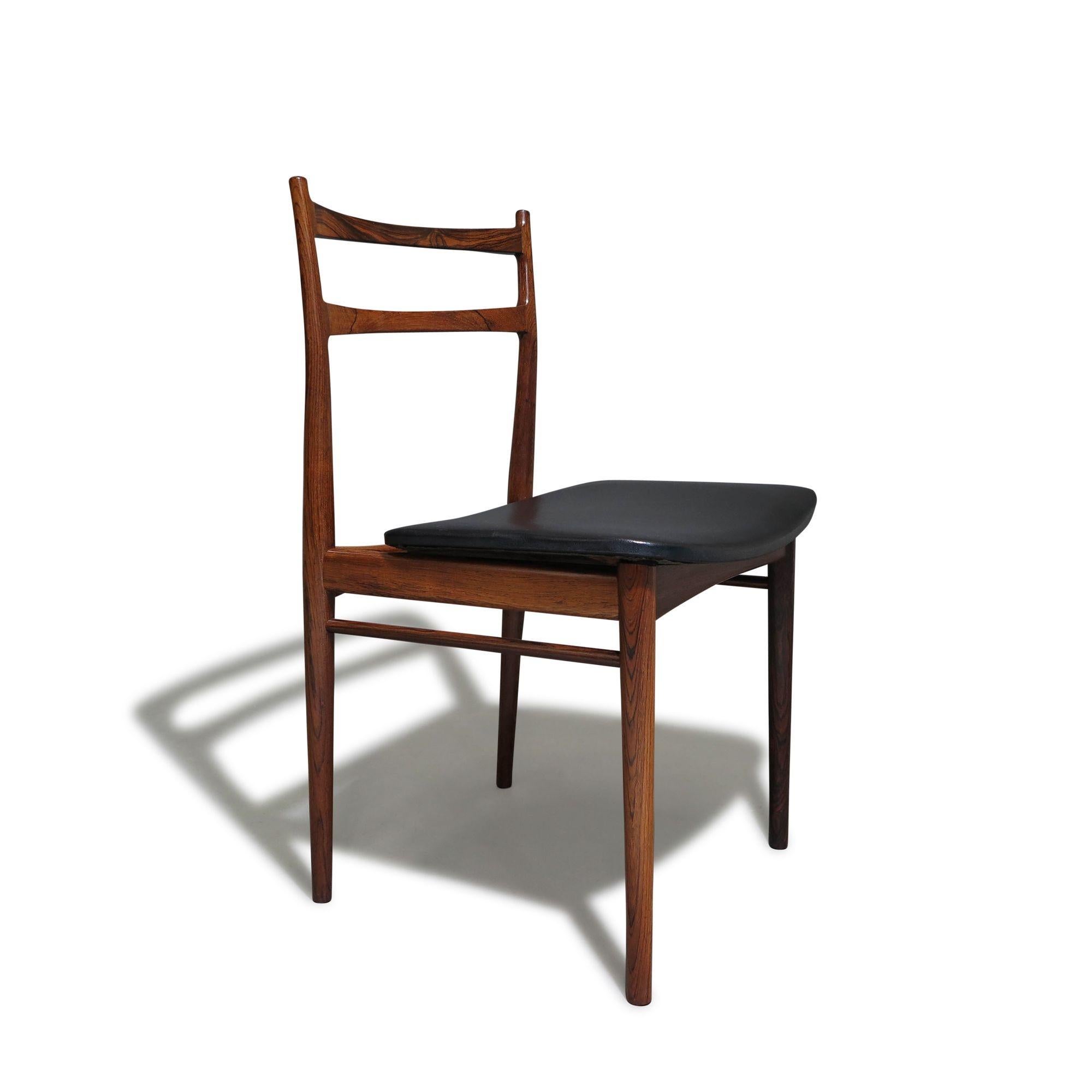 Minimal and classic form dining chairs designed by Henry Rosengren Hansen for Brande Mobelindustri, Denmark in 1958. The elegant set of six chairs feature sculpted solid Brazilian rosewood frames; lightly restored preserving the original patina and