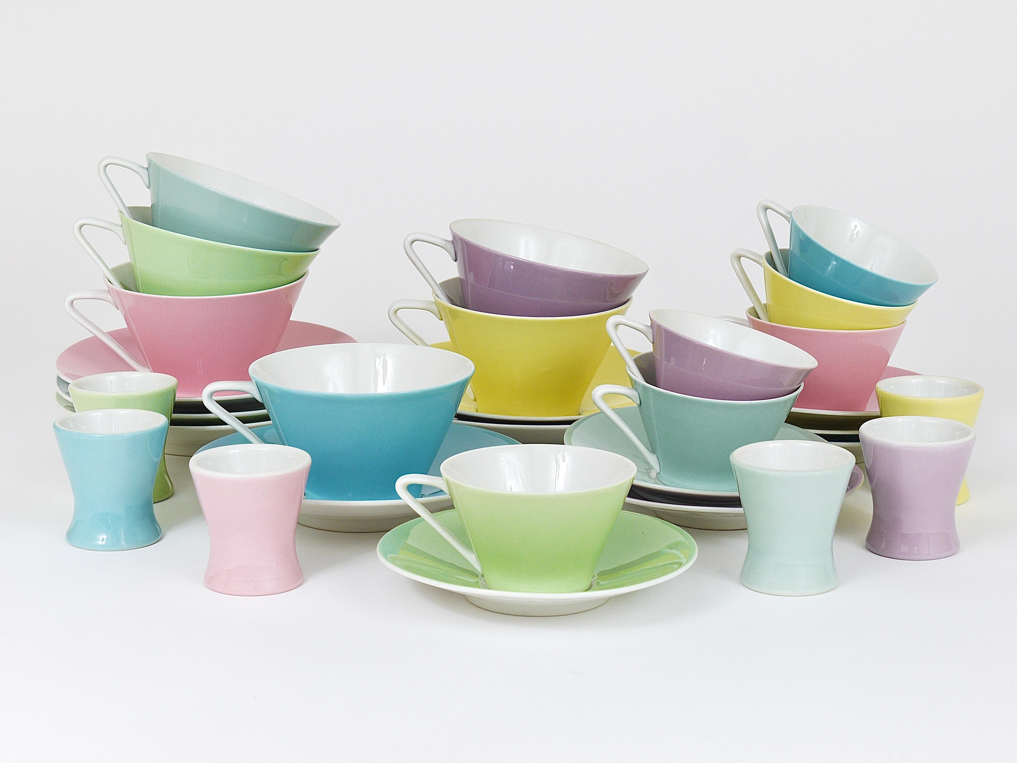 A set of six charming conical coffee cups and saucers from the „Daisy“-series, made of thin, fine china in six different lovely pastel colors, yellow, light blue, light green, bluegray, pink/rosé and lilac. Made in the 1950s by Lilien Porzellan