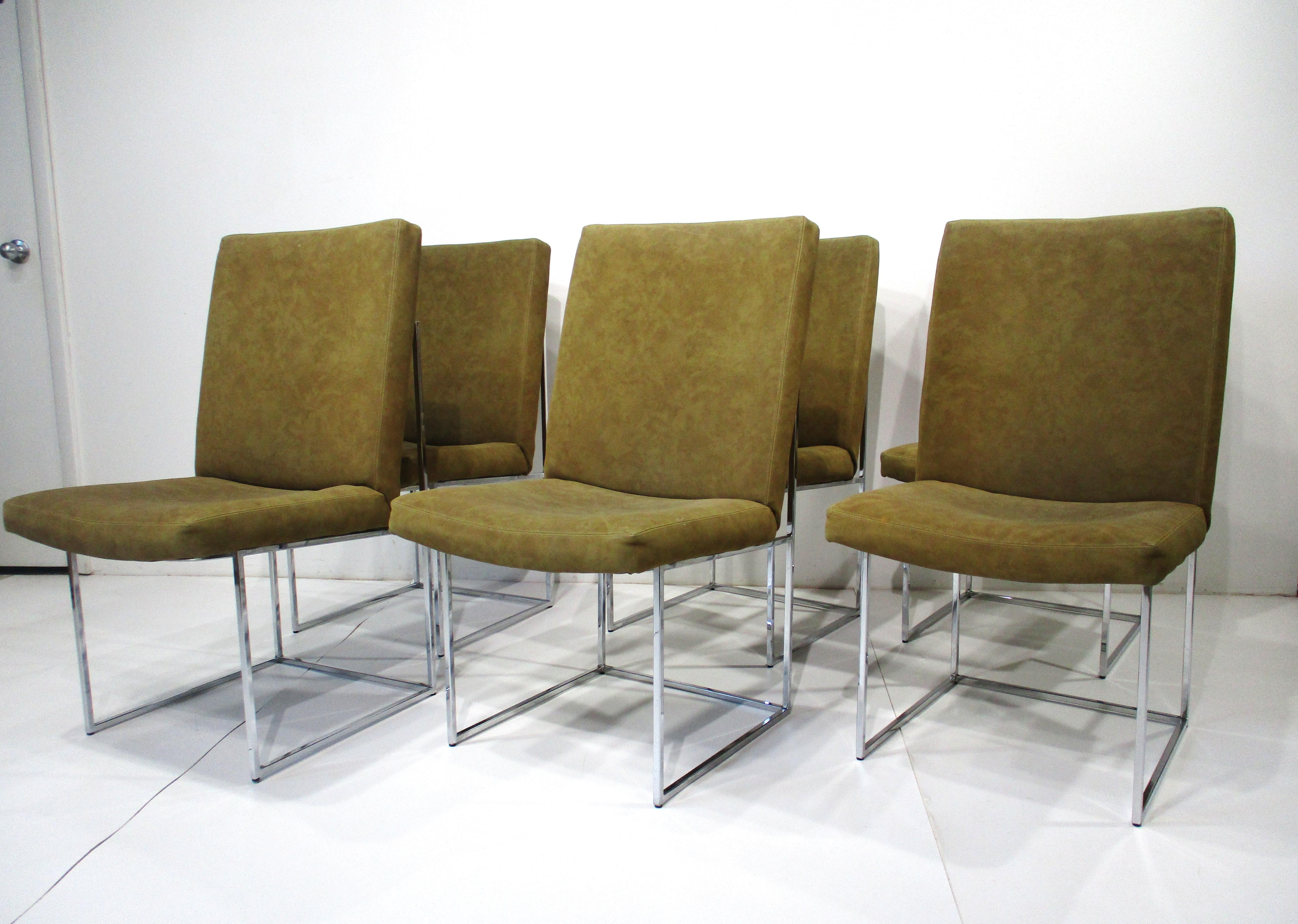 A set of six chrome squared tubed framed higher backed dining chairs in a dark tan ultra suede by designer Milo Baughman . Giving plenty of comfort with the taller backs and with a form that's able to fitting into many different styles and interiors