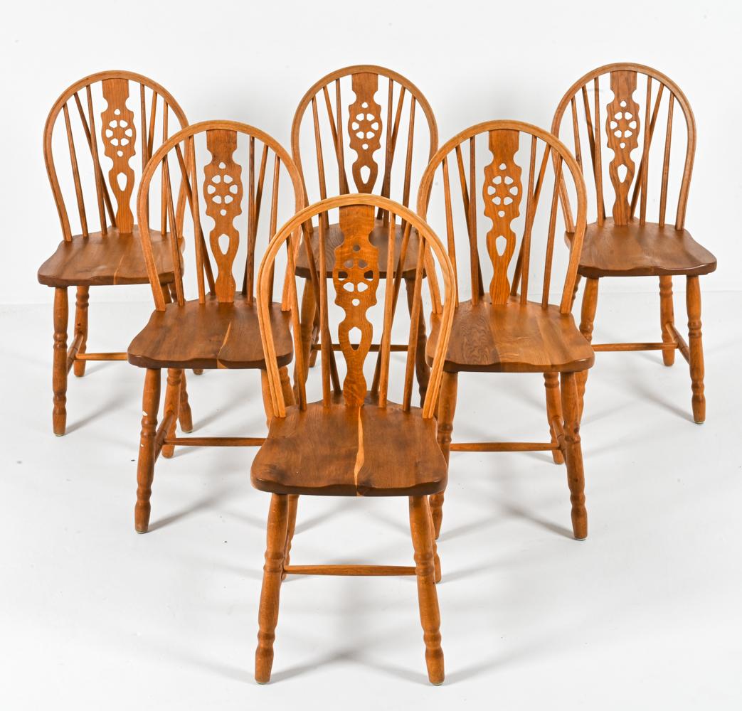 Lend a touch of Danish modern elegance to your dining space with this exquisite set of six Windsor style side chairs. Crafted from warm oak in the manner of Frits Henningsen, these chairs, made in the 1990s, offer a timeless combination of