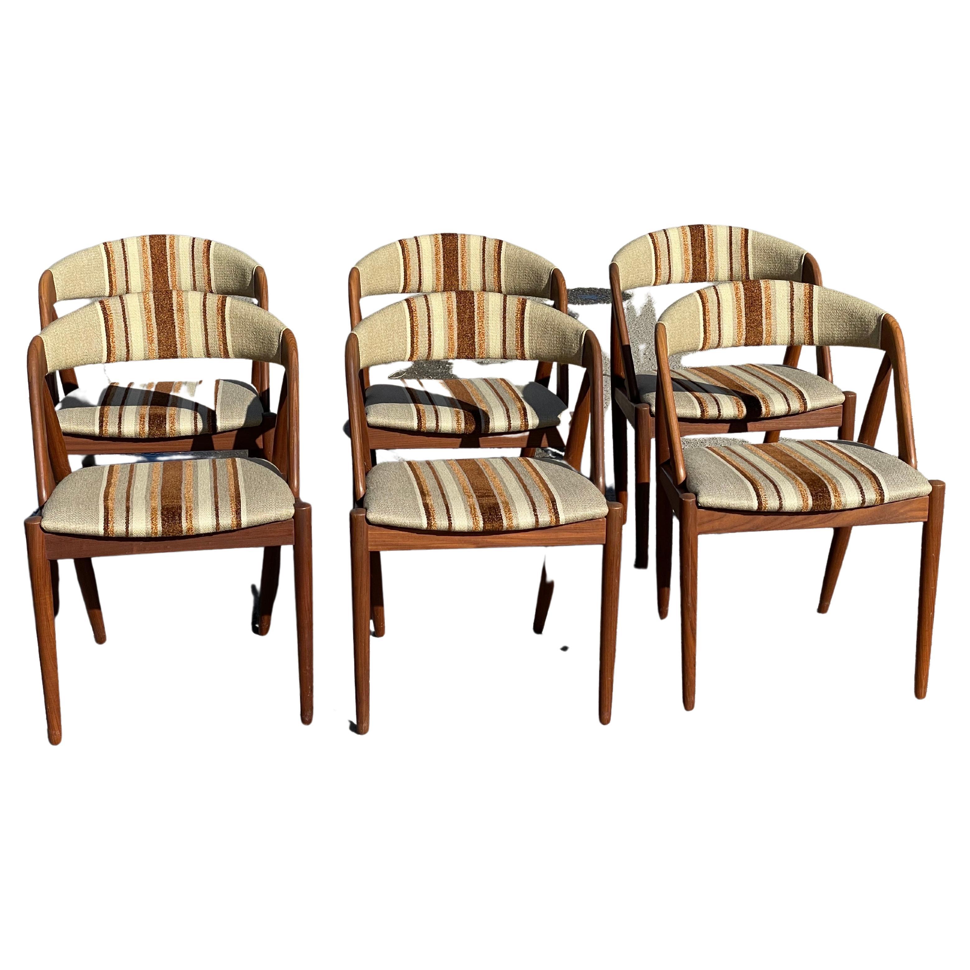 Elegant set of 6 'model 31' dining chairs designed by Kai Kristiansen and manufactured by Schou Andersen, Denmark 1956. These typical Danish Modern dining chairs have solid teak frames and in the original upholstery. Another nice detail is the back